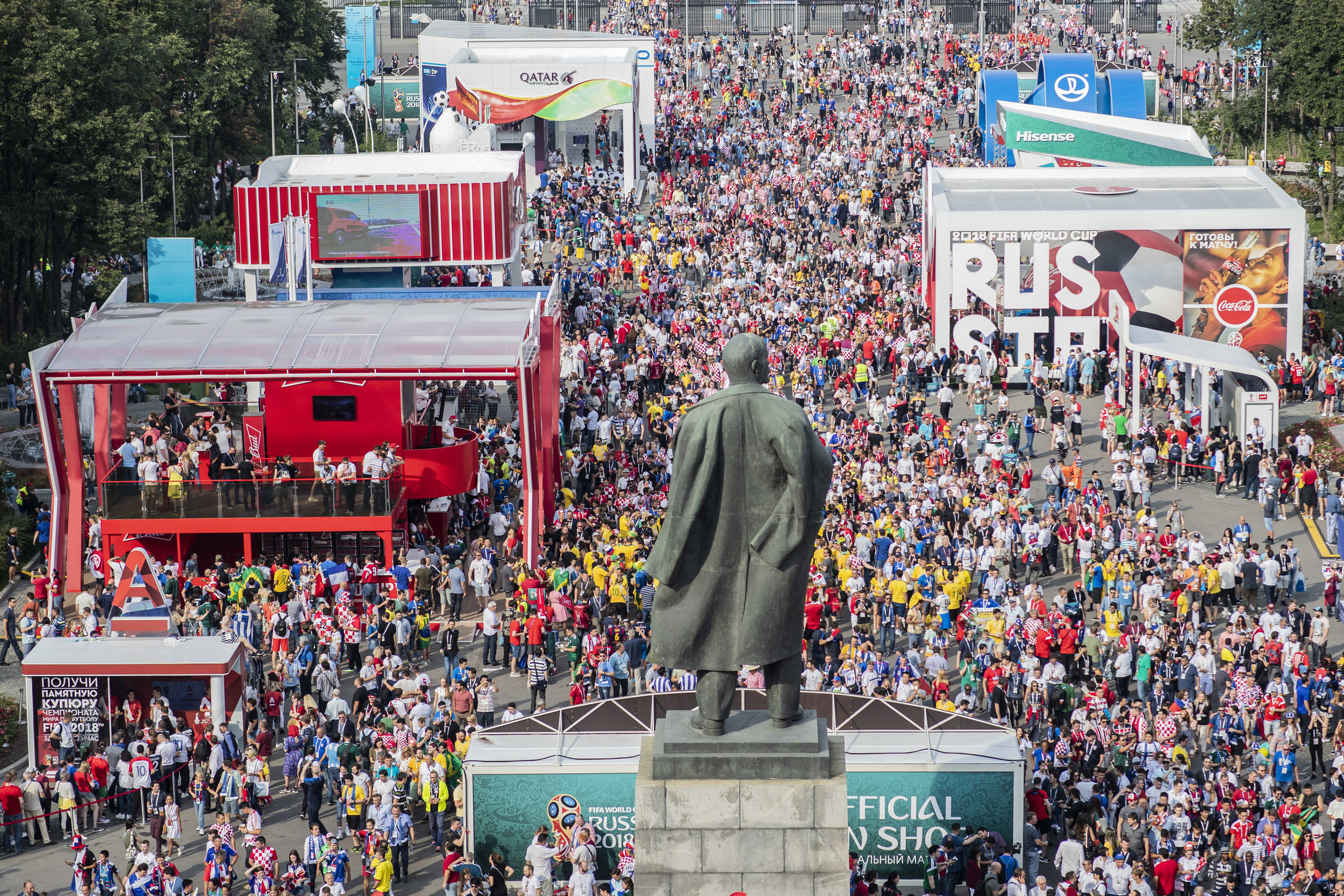  Fans of all nations enter Luzhniki stadium passing by Lenin's statue and an alley filled with sponsors' pavilions in Moscow 