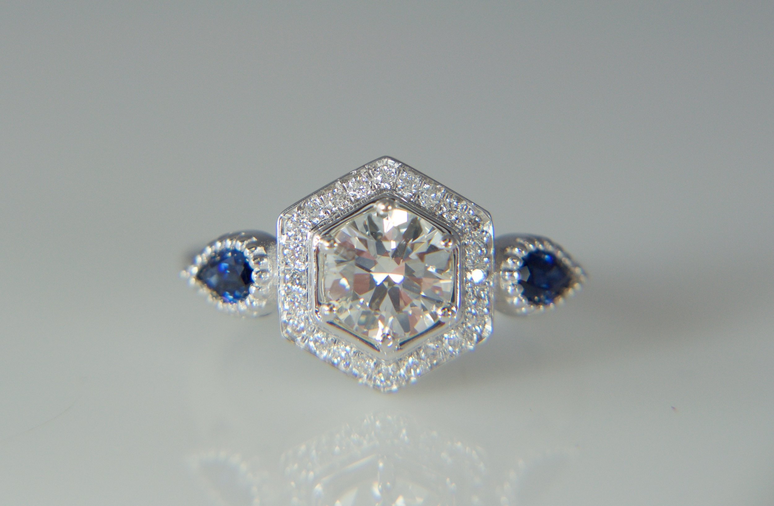 Round diamond halo engagement ring with sapphires