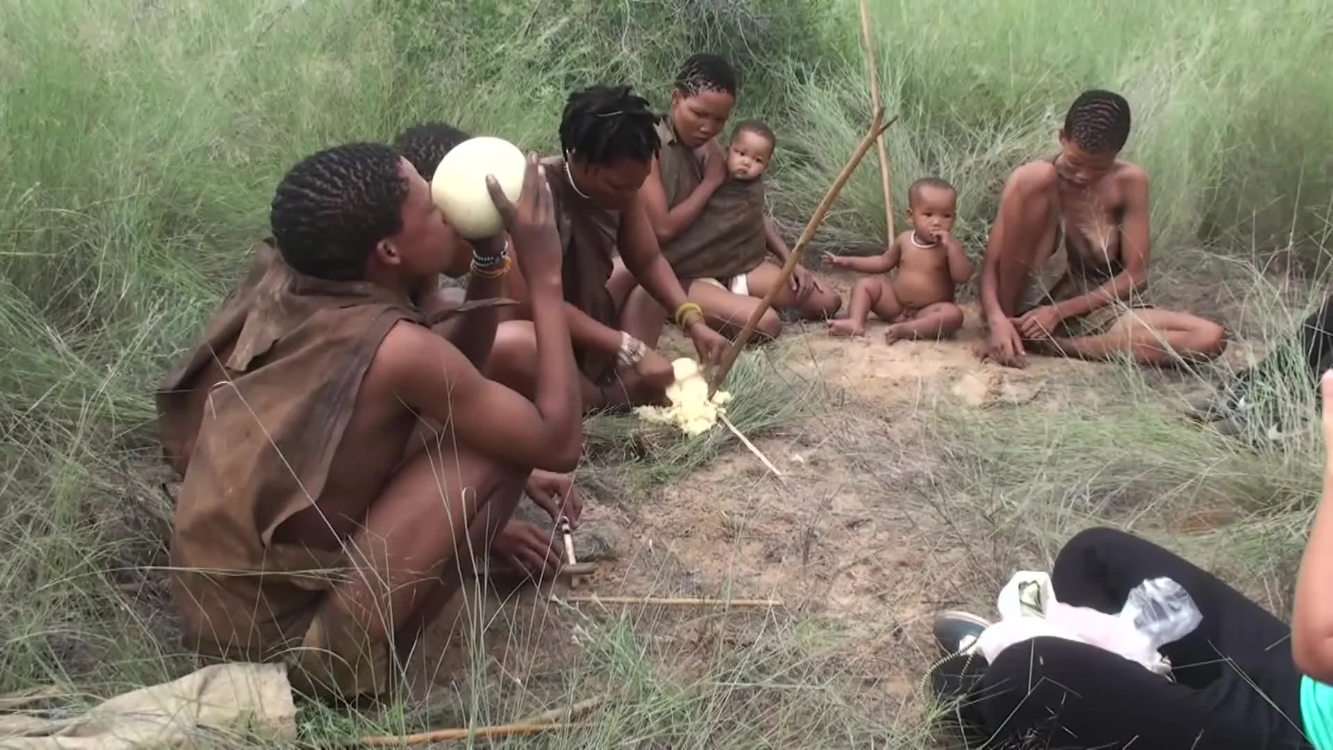Everyone sharing water from an Ostrich egg. Everyone is thirsty or no one is thirsty.