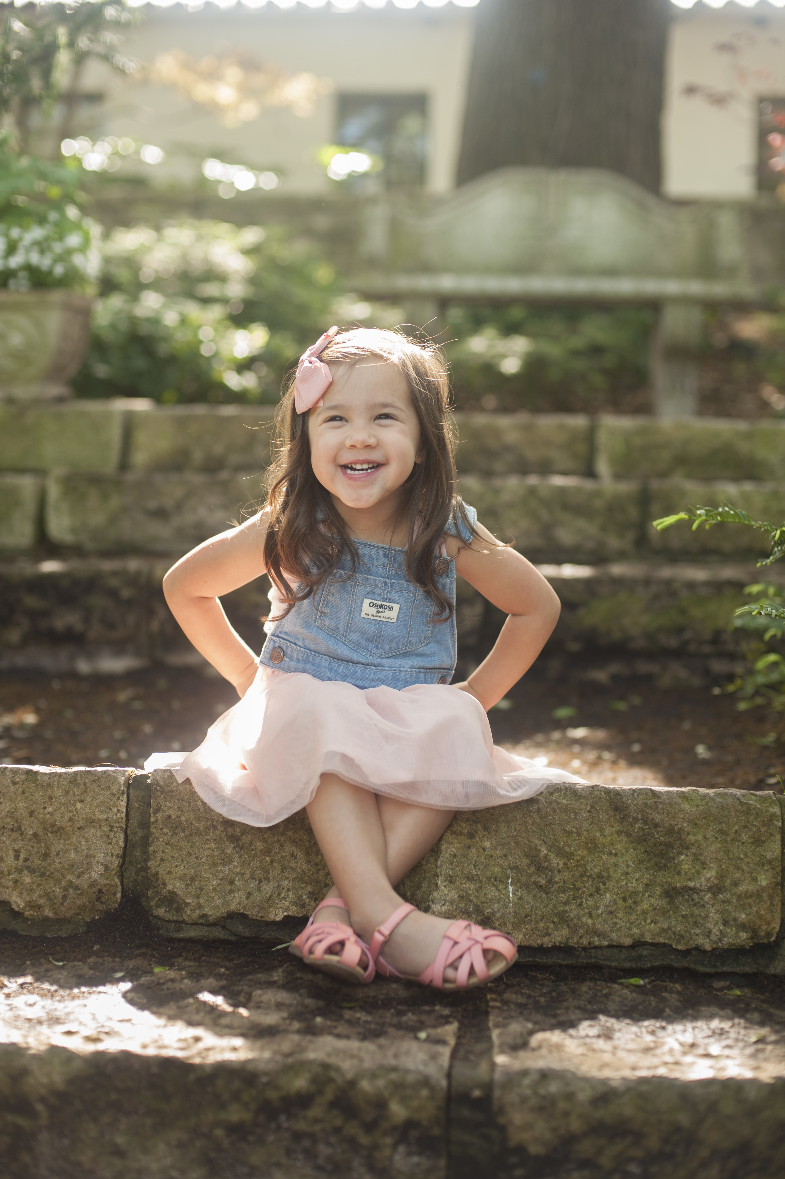 Sassy toddler sitting on stone steps. Childrens portrait at the Dallas Arboretum.
