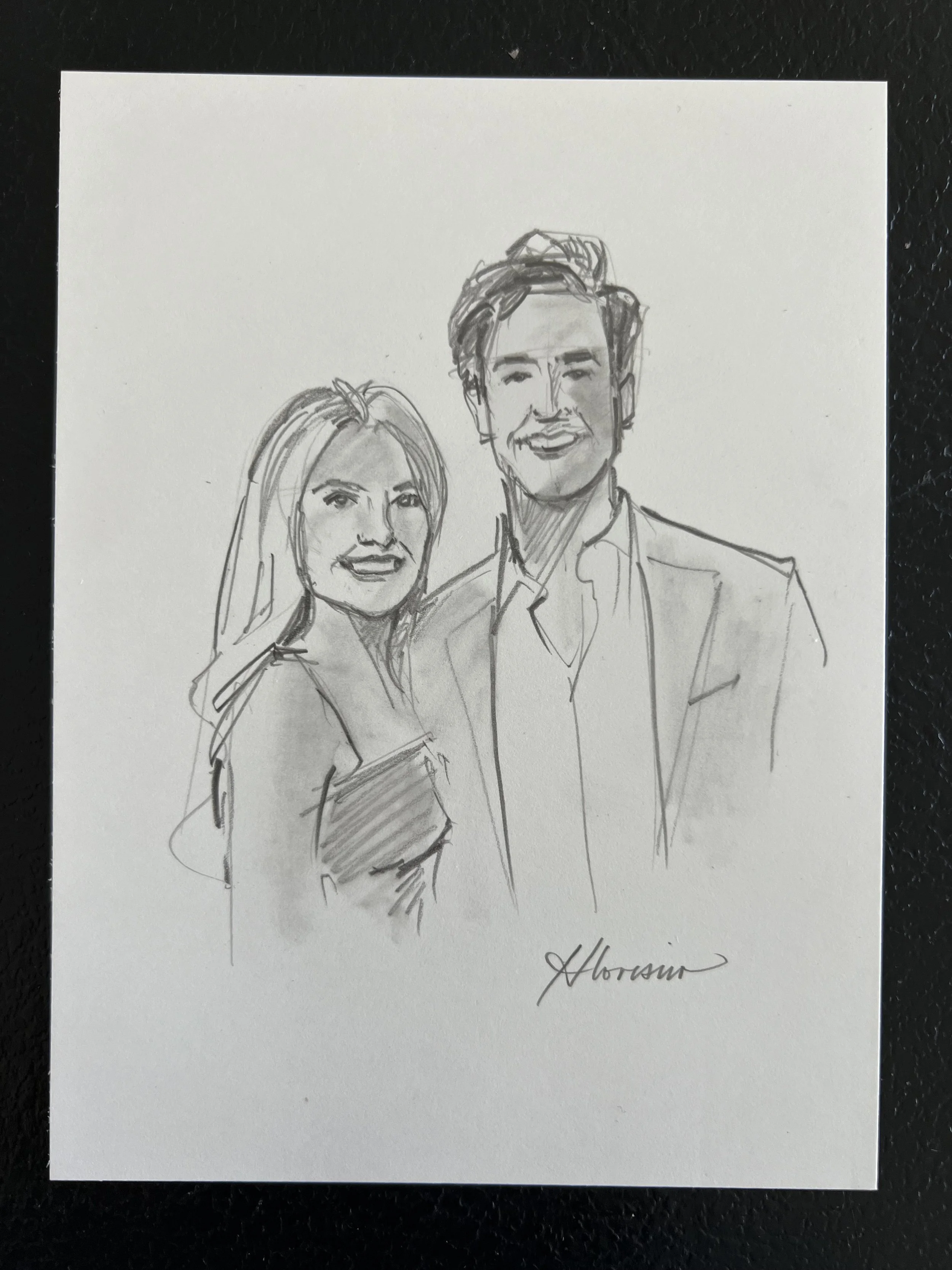 A black and white sketch of a smiling man and woman standing close together, with the man's arm around the woman's back. The woman has long hair and is holding a book or folder. The man's hair is styled back, and he is wearing a suit jacket with a sh