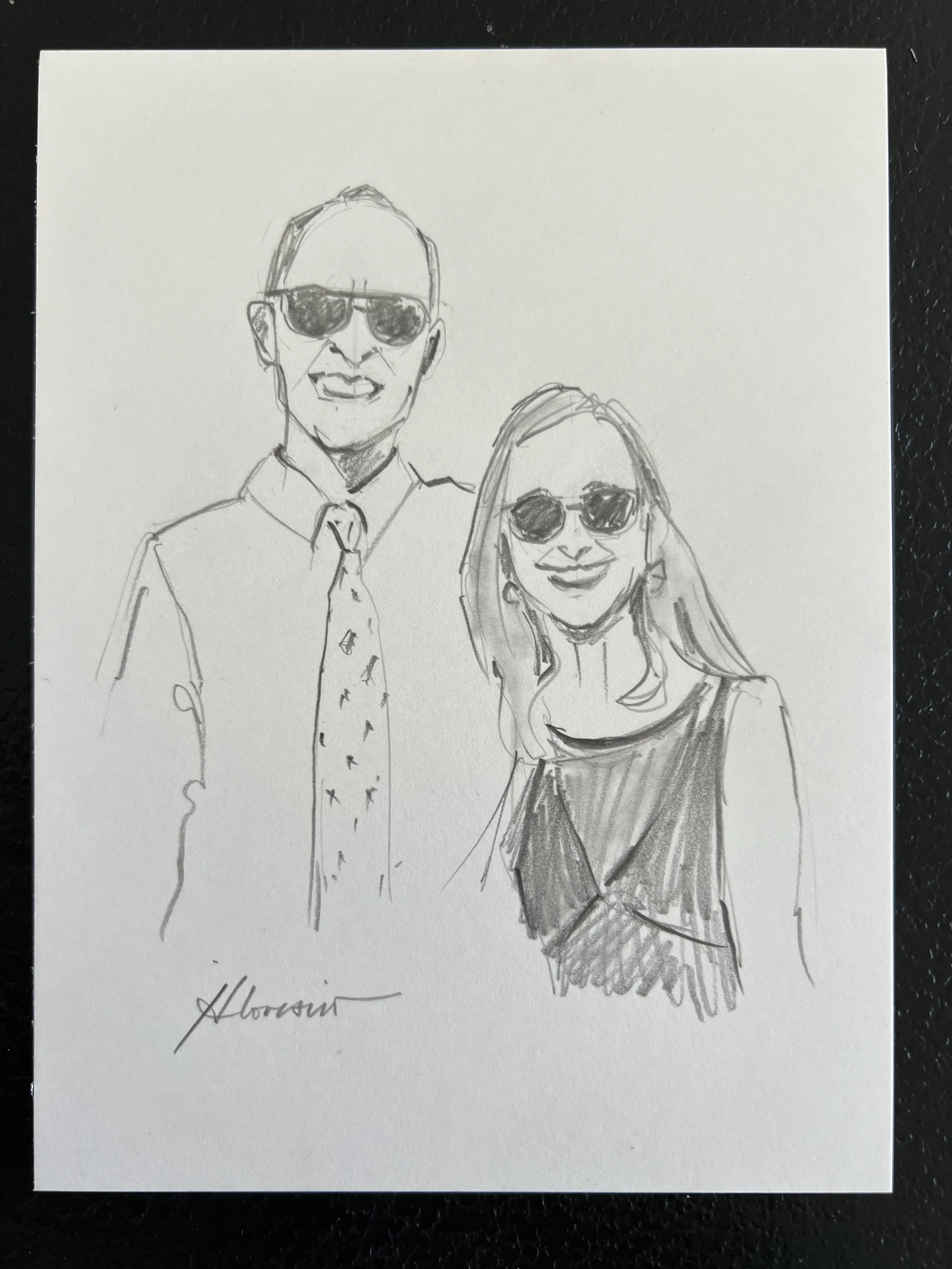 A pencil sketch of a man and woman wearing sunglasses, smiling. The man is dressed in a collared shirt with a floral tie, and the woman is wearing a sleeveless top. The sketch is signed at the bottom left.