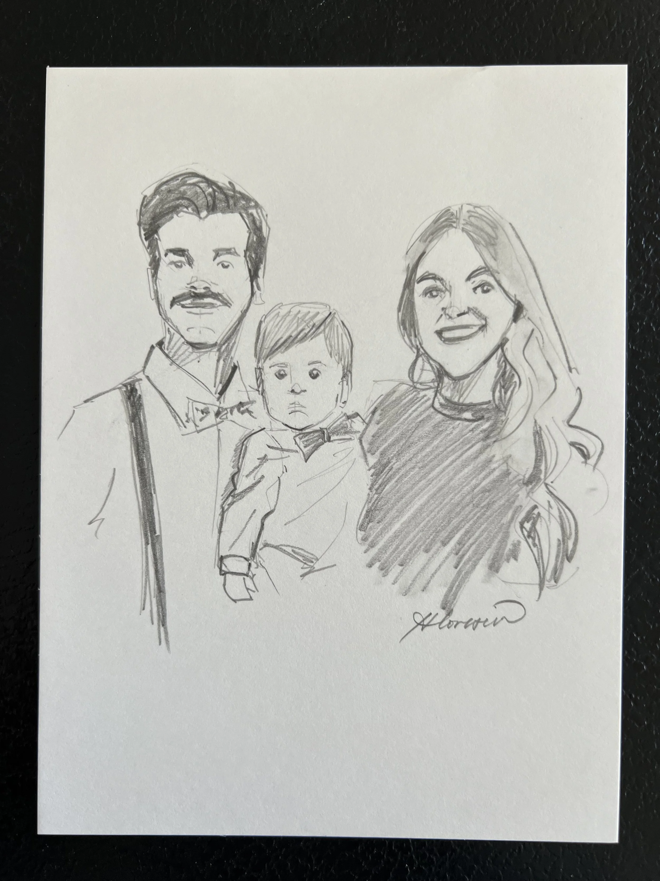 Sketch of a family of three, with a man, woman, and child, drawn with pencil on paper.