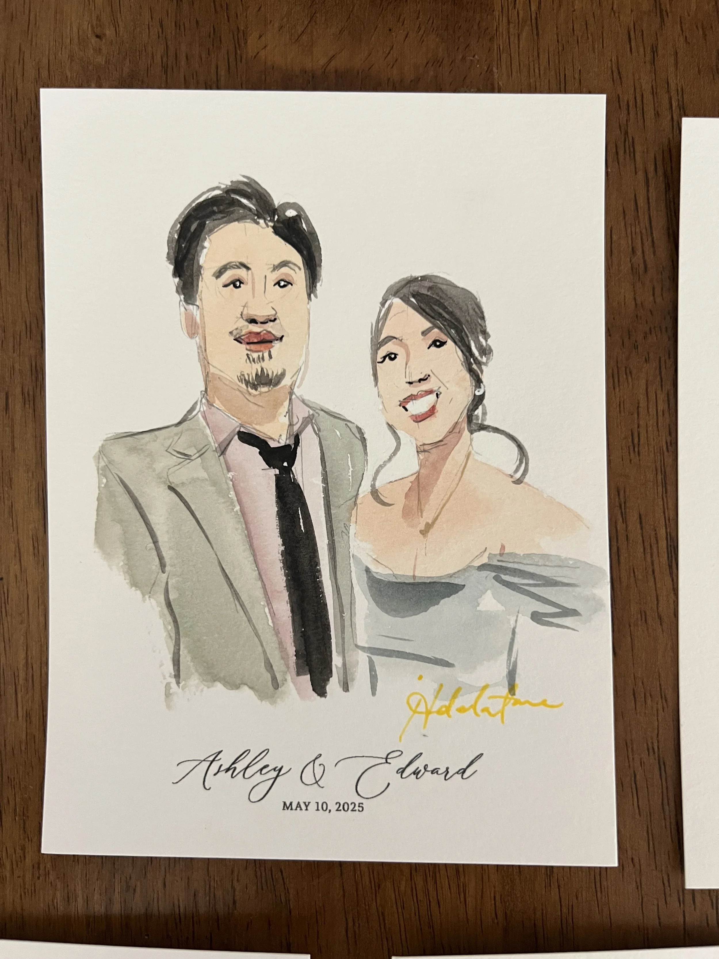A watercolor portrait of a man and woman on a card, with the names Ashley and Edward and the date May 10, 2025, written below.
