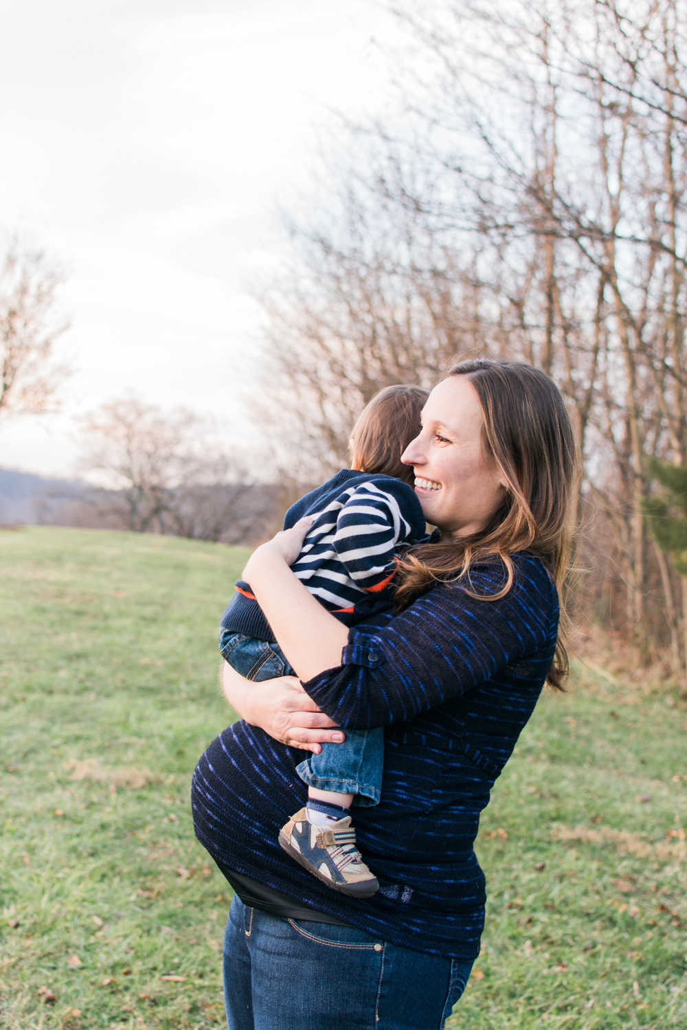 Warwickshire Mother hug son as he sits on her pregnant belly.