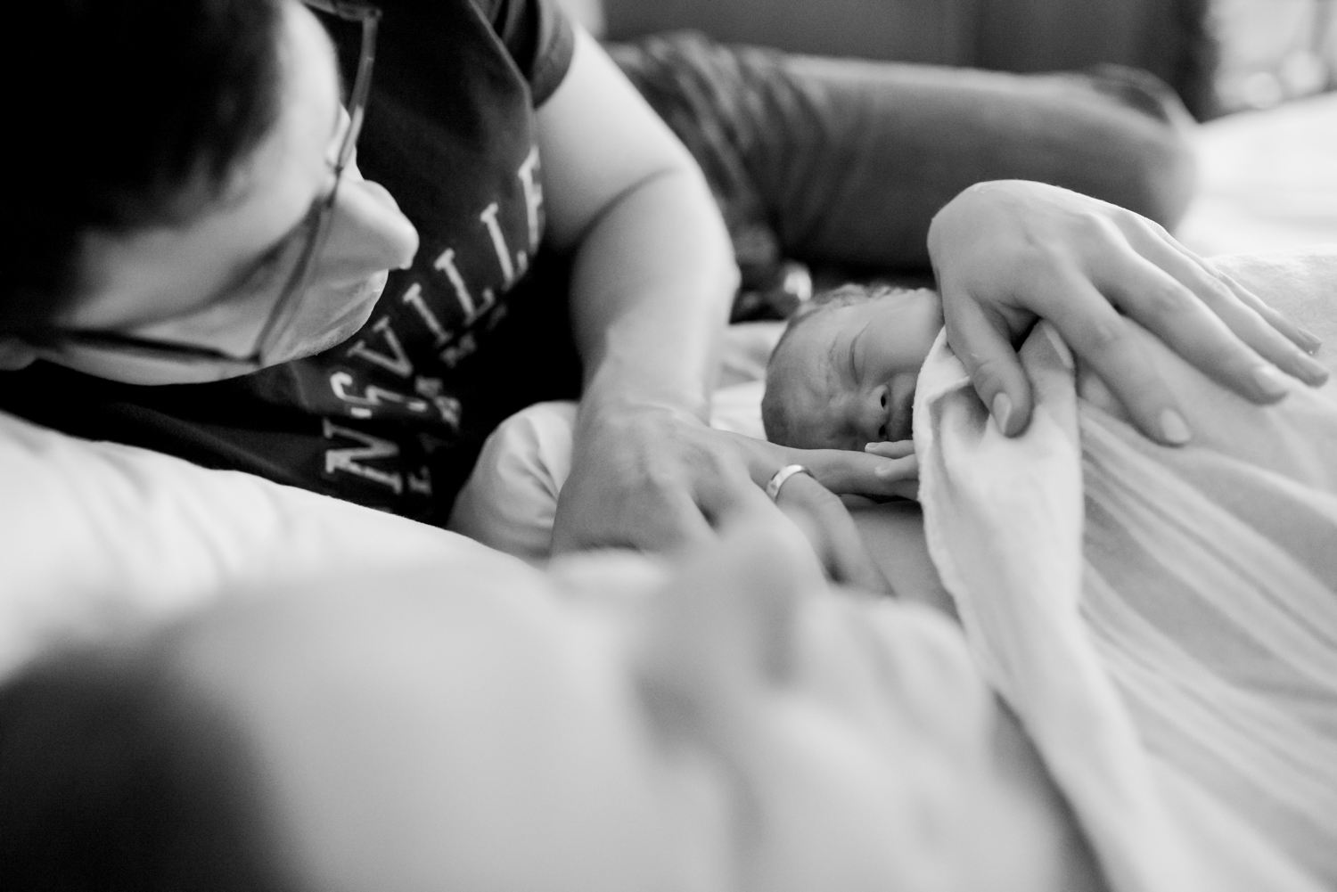 UK Birth Photographer shows mum and dad holding their brand new baby at their Bicester, Oxfordshire homebirth.