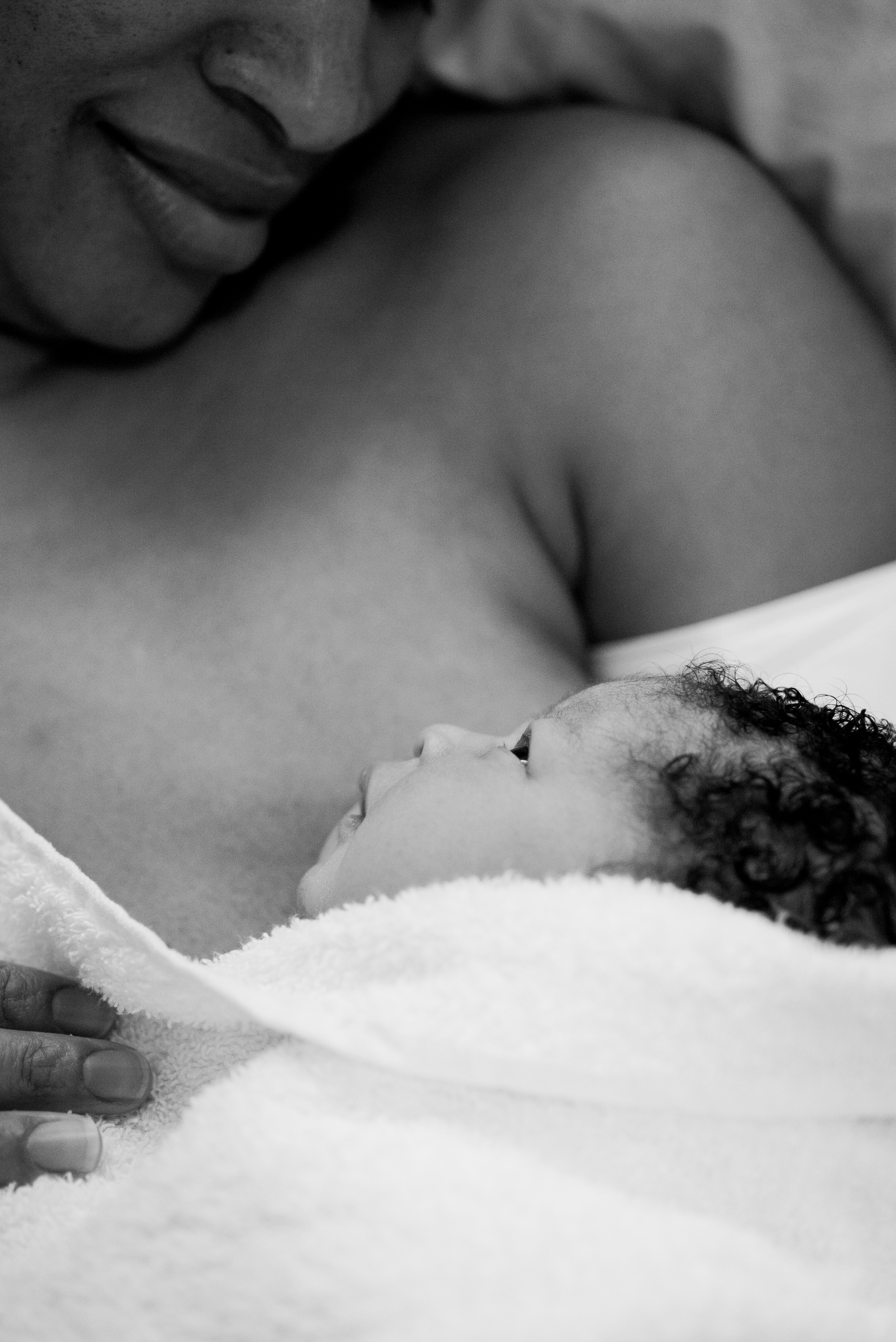 London mum cradles her newborn just after birth in hospital captured by UK Birth Photographer Aimee Durrance.