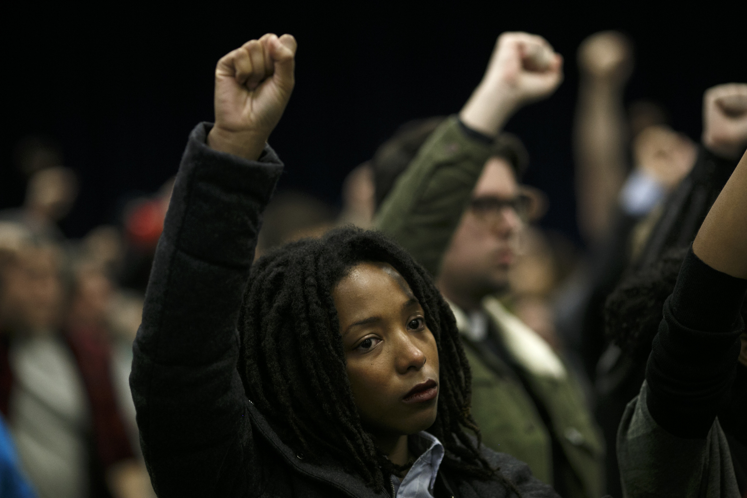 Attendees raise their fists in protest during the November Police Board Meeting at the Chicago Public Safety Headquarters on November 19, 2015 (Jonathan Gibby/City Bureau)