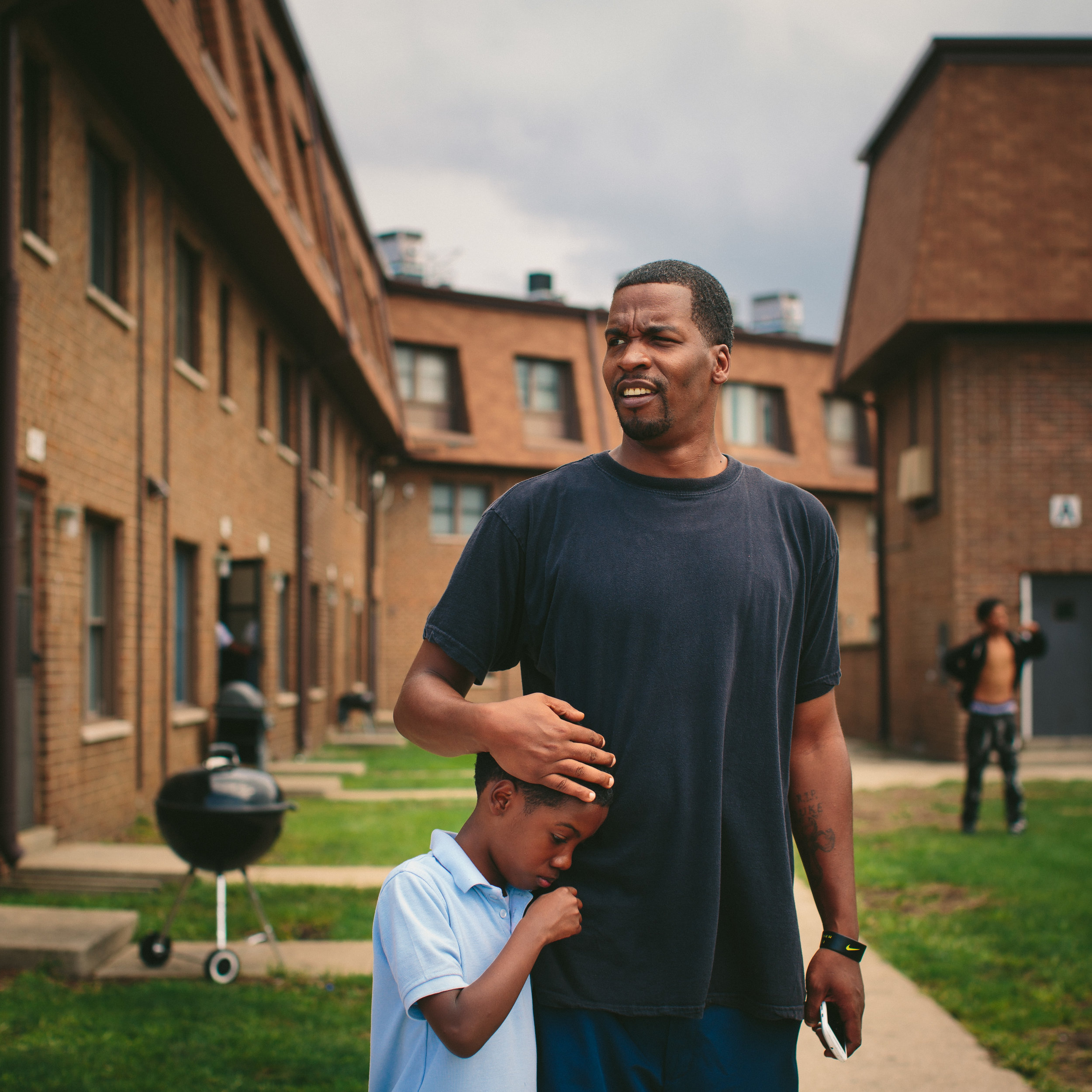   Lamont Anderson embraces his son Lamont Anderson Jr., 8, at the West Calumet Housing Complex. Anderson Jr.’s blood lead levels test results were above the CDCs 5 mg/d threshold for action. After living in the complex for more than a decade, the fa