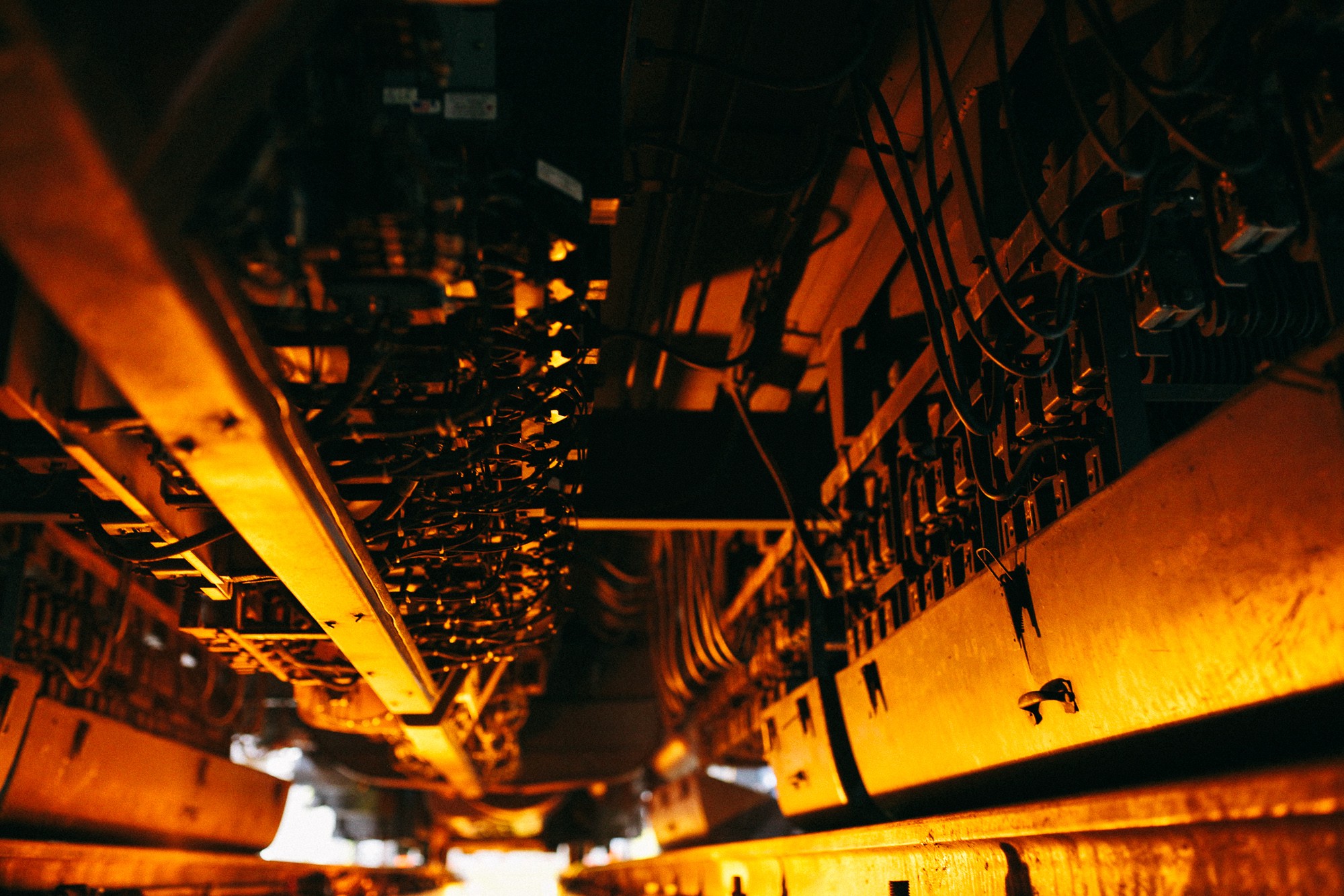The underbelly of a newer Metra car, a complex system of brakes and compressors.