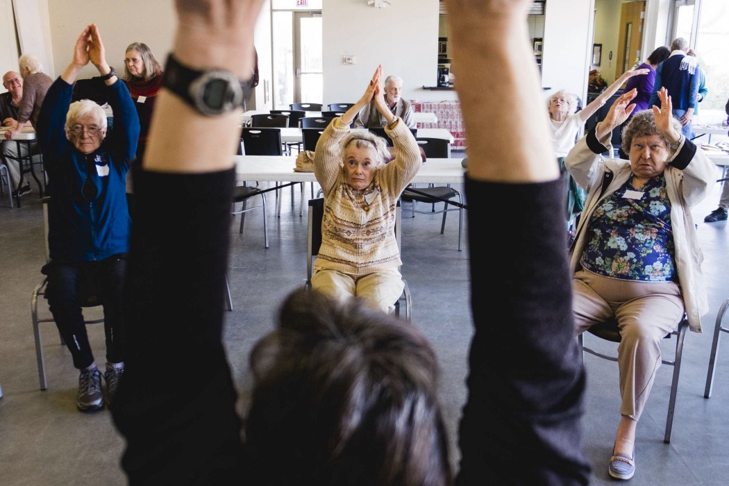 Marcia Cozzi, center, exercises with other members of the Chicago Hyde Park Village during a bi-monthly drop-in. As one of Chicago Hyde Park Village’s partners, SHARE Network sponsors some of its drop-ins, where seniors can exercise and interact with other community members over lunch. (Photo: Pat Nabong)