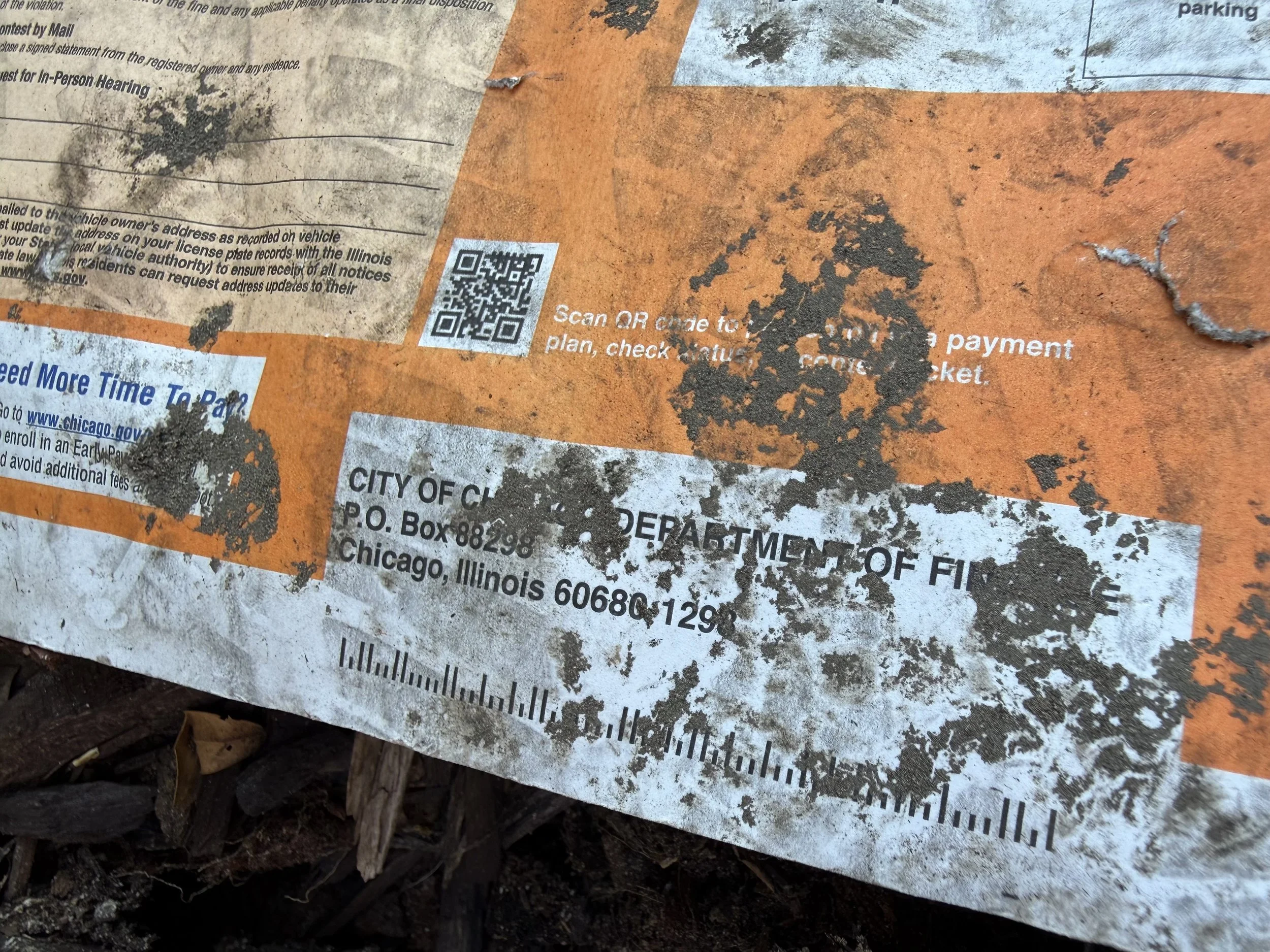 A dirt-covered envelope for a Chicago parking ticket was found discarded on a sidewalk in the South Loop.
