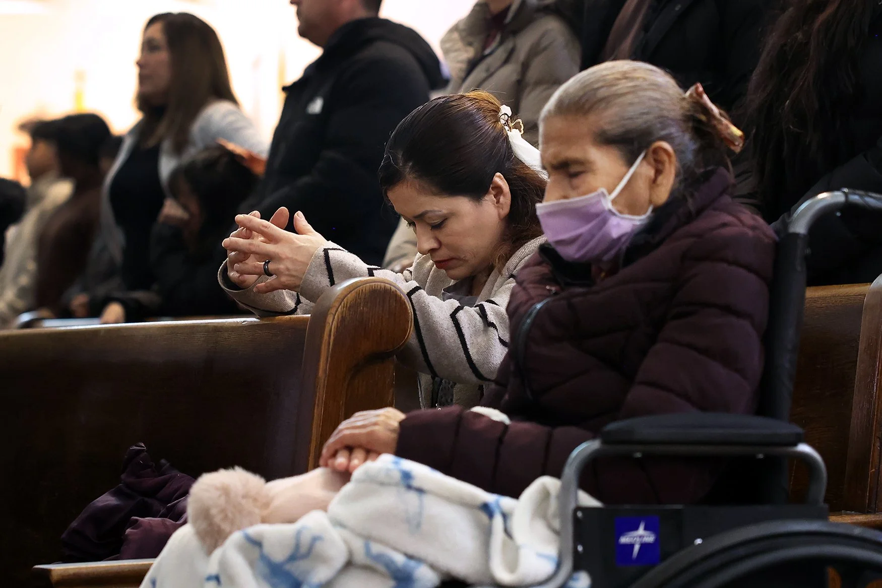 A woman prays at a pew inside St. Joseph.