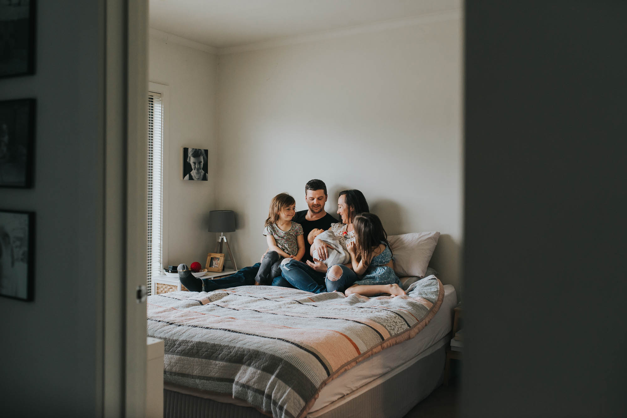 newborn photo session with family snuggling together on the bed 