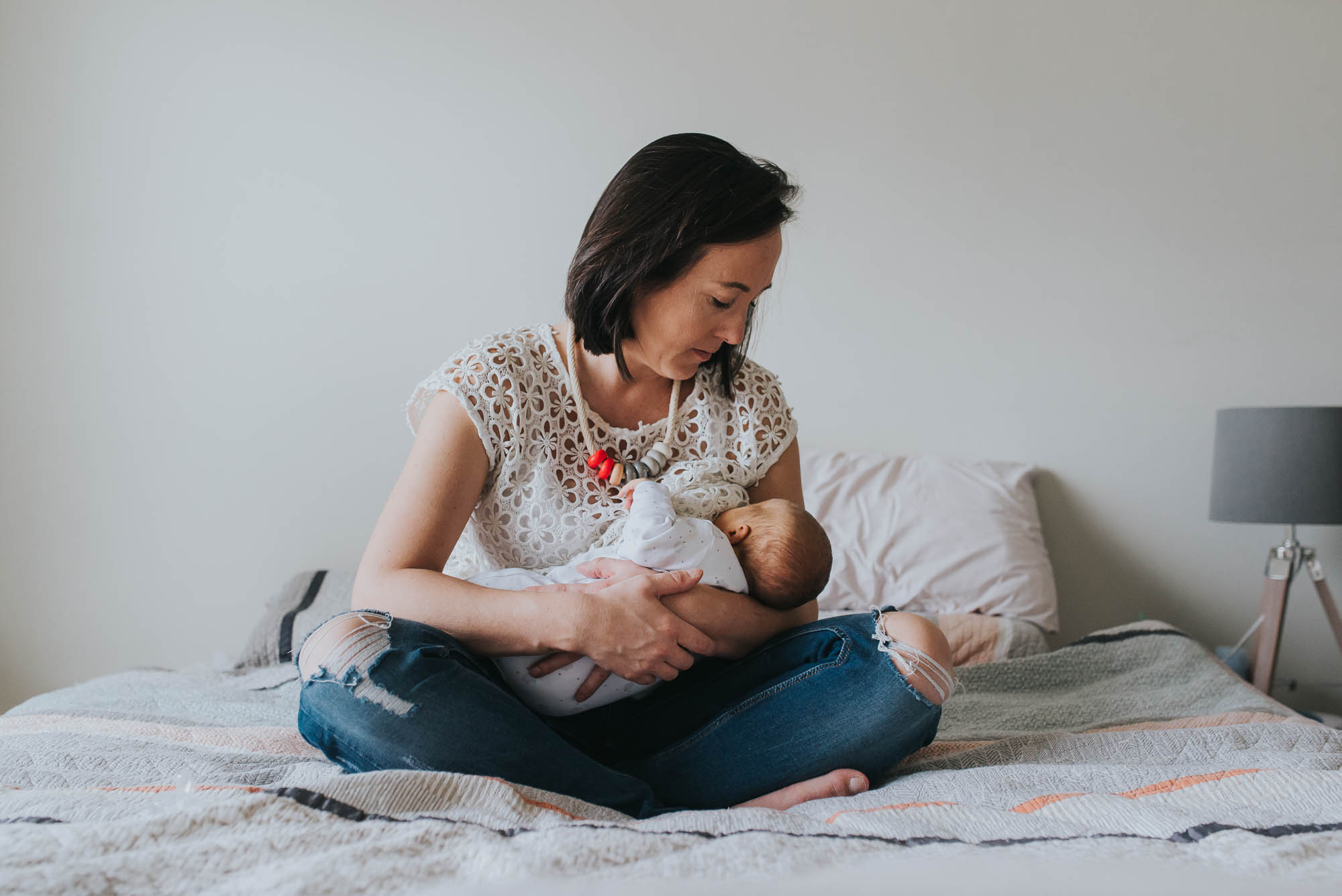 mom breastfeeding newborn baby at an in-home lifestyle newborn photo session