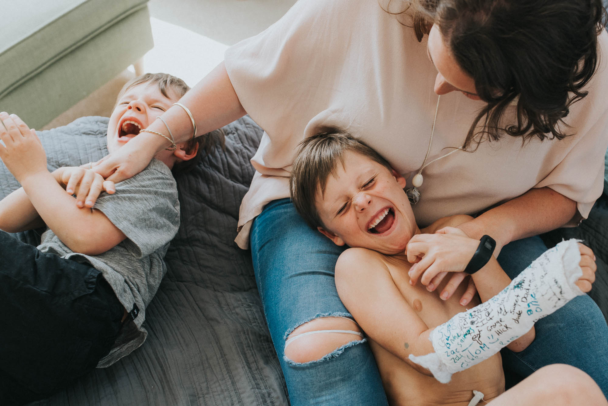 boys laughing while being tickled by their mum