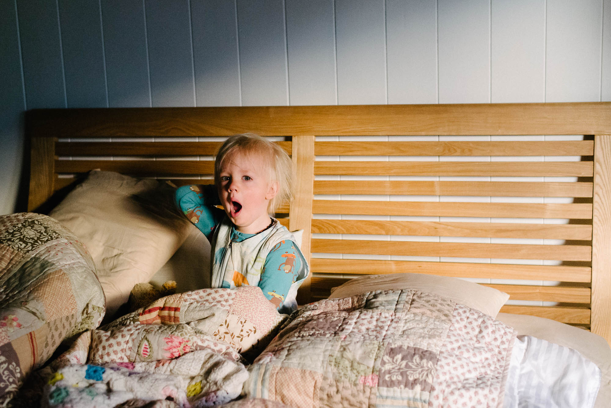 boy-yawning-in-bed-in-morning-light