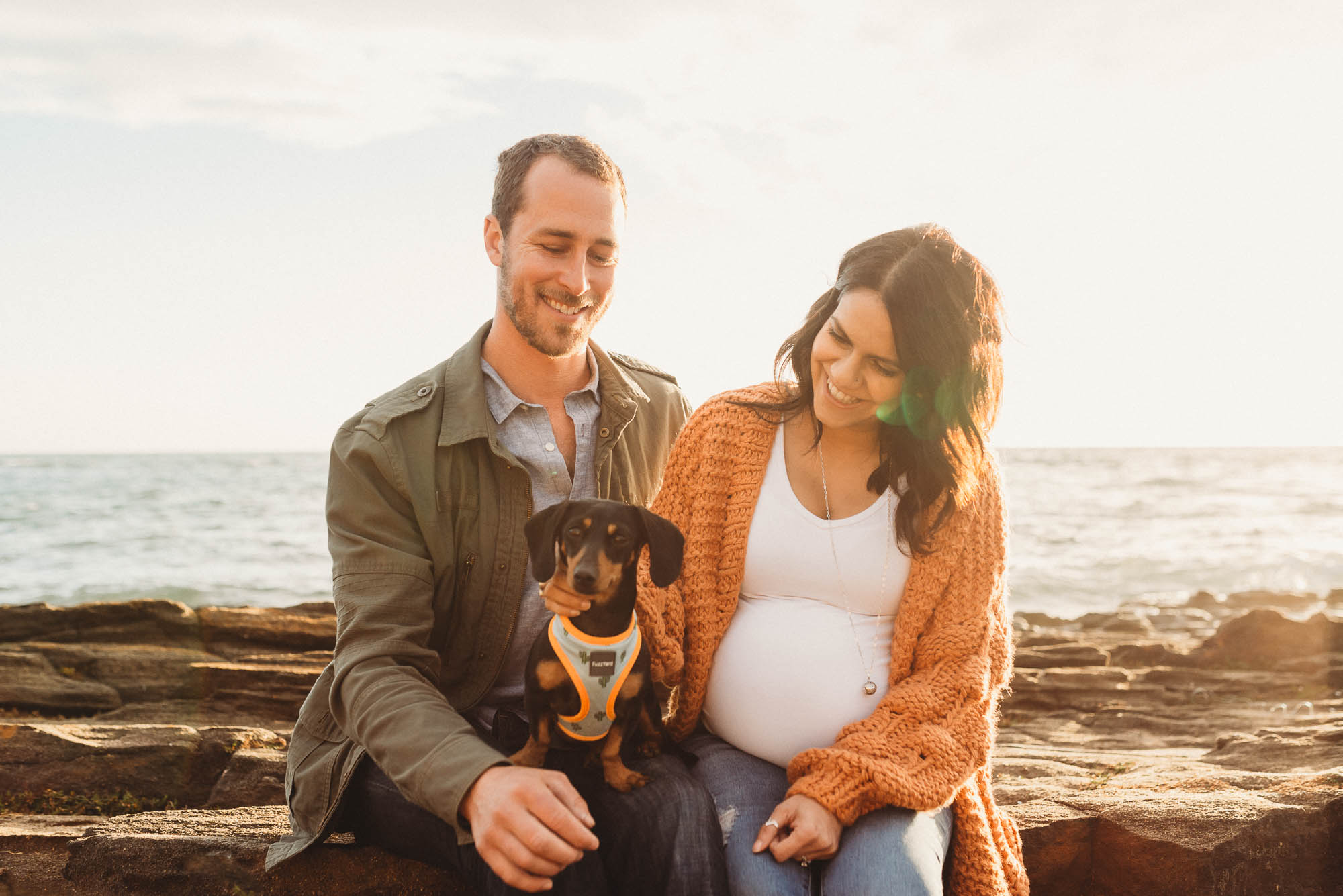 melbourne_maternity_photographer_jenny_rusby_photography_couple_sitting_together__on_rocks_with_dog_at_the_beach