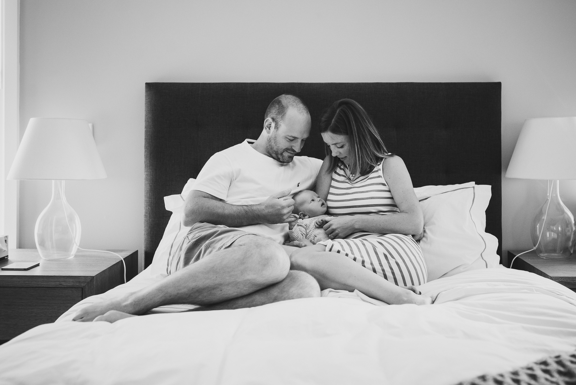 mum-dad-and-newborn-cuddling-on-the-bed-black-and-white-newborn-photography-melbourne-jenny-rusby-photography.jpg