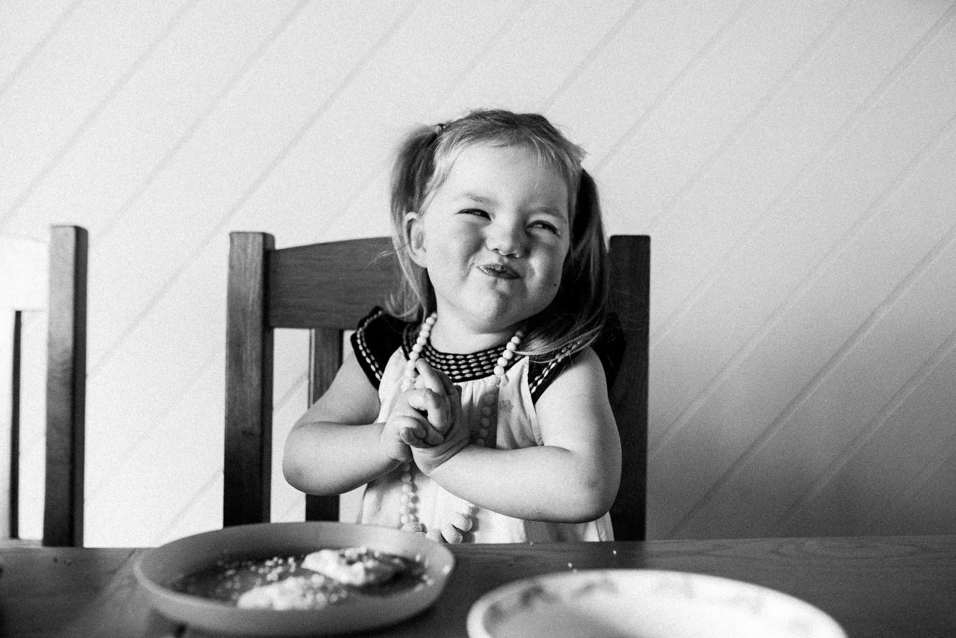 child-smiling-after-eating-cookie-at-kitchen-table-black-and-white-melbourne-family-photographer.jpg
