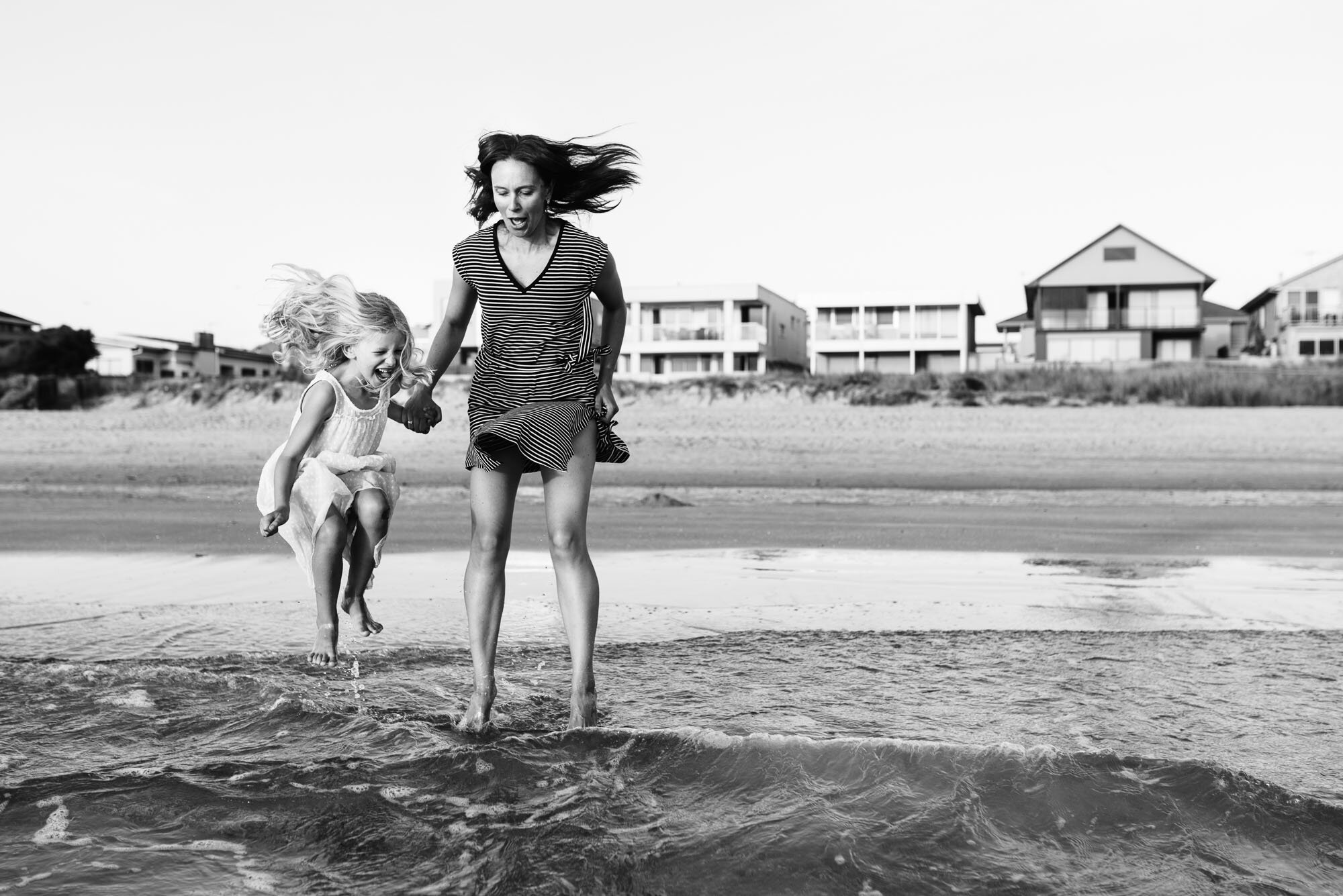 mother_and_daughter_jumping_waves_at_the_beach_photographer_melboune.jpg