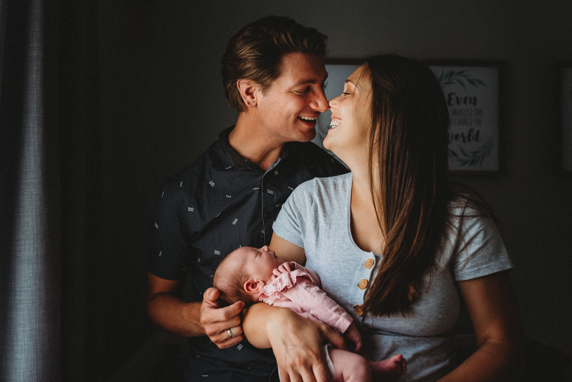 couple_smiling_at_each_other_holding_newborn_baby__at_home_melbourne_photographer.jpg