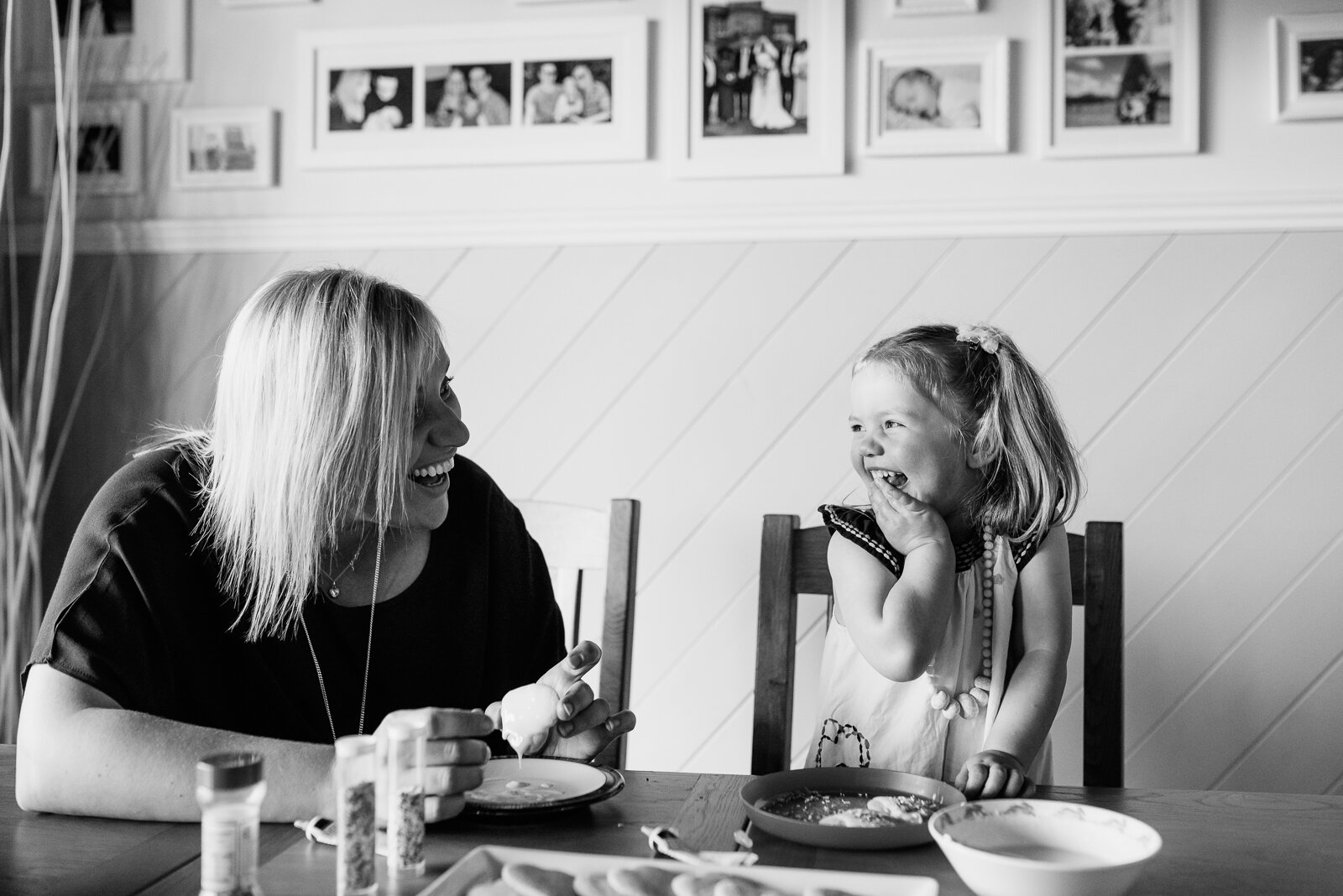 mum_and_daughter_smiling_decorating_cookis_at_table_melbourne_family_photographer_in_home.jpg