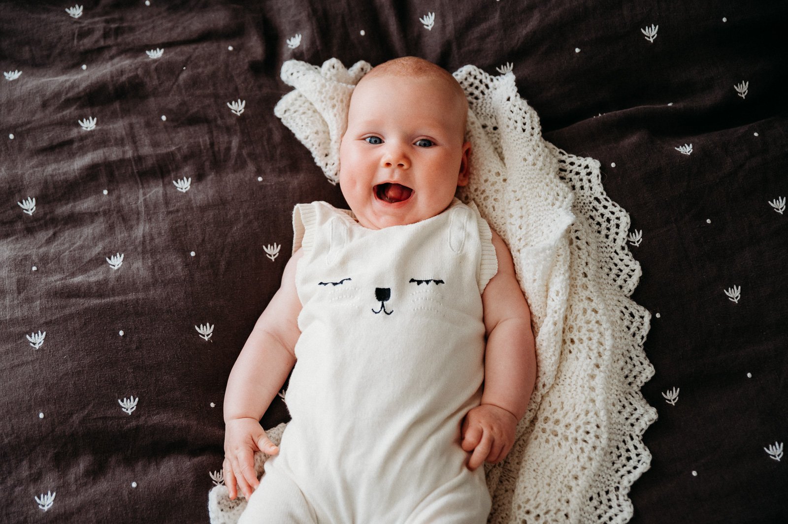 baby_smiling_at_home_on_bed_from_above_melbourne_newborn_family_photographer_lifestyle-1.jpg