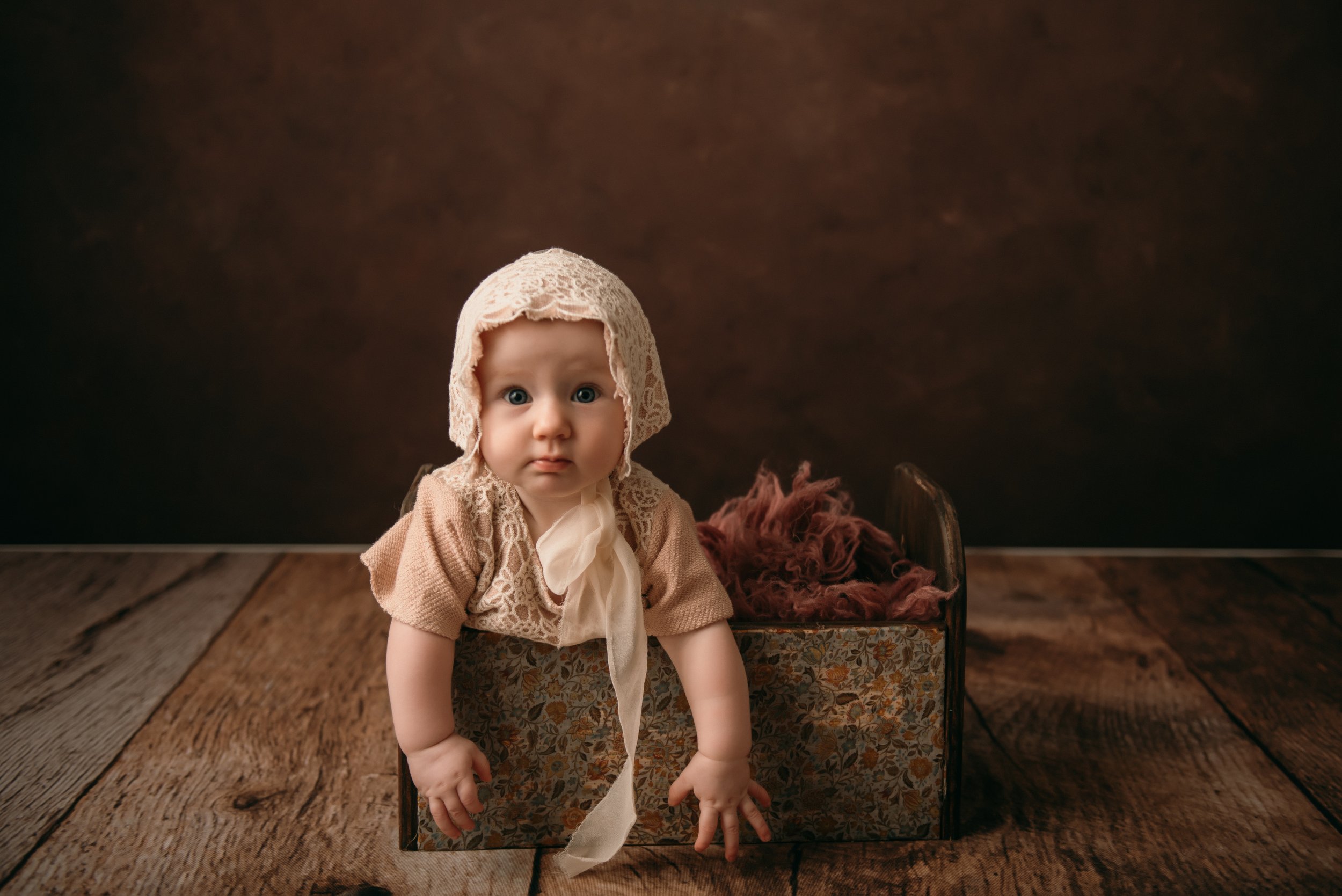a baby sitting in a small bed