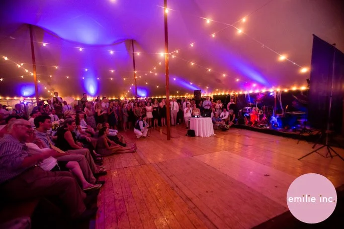 Exposed cafe lights installed throughout a double-wide Sperry Tent, private wedding in Cumberland Foreside Maine. Image by Emilie Inc .