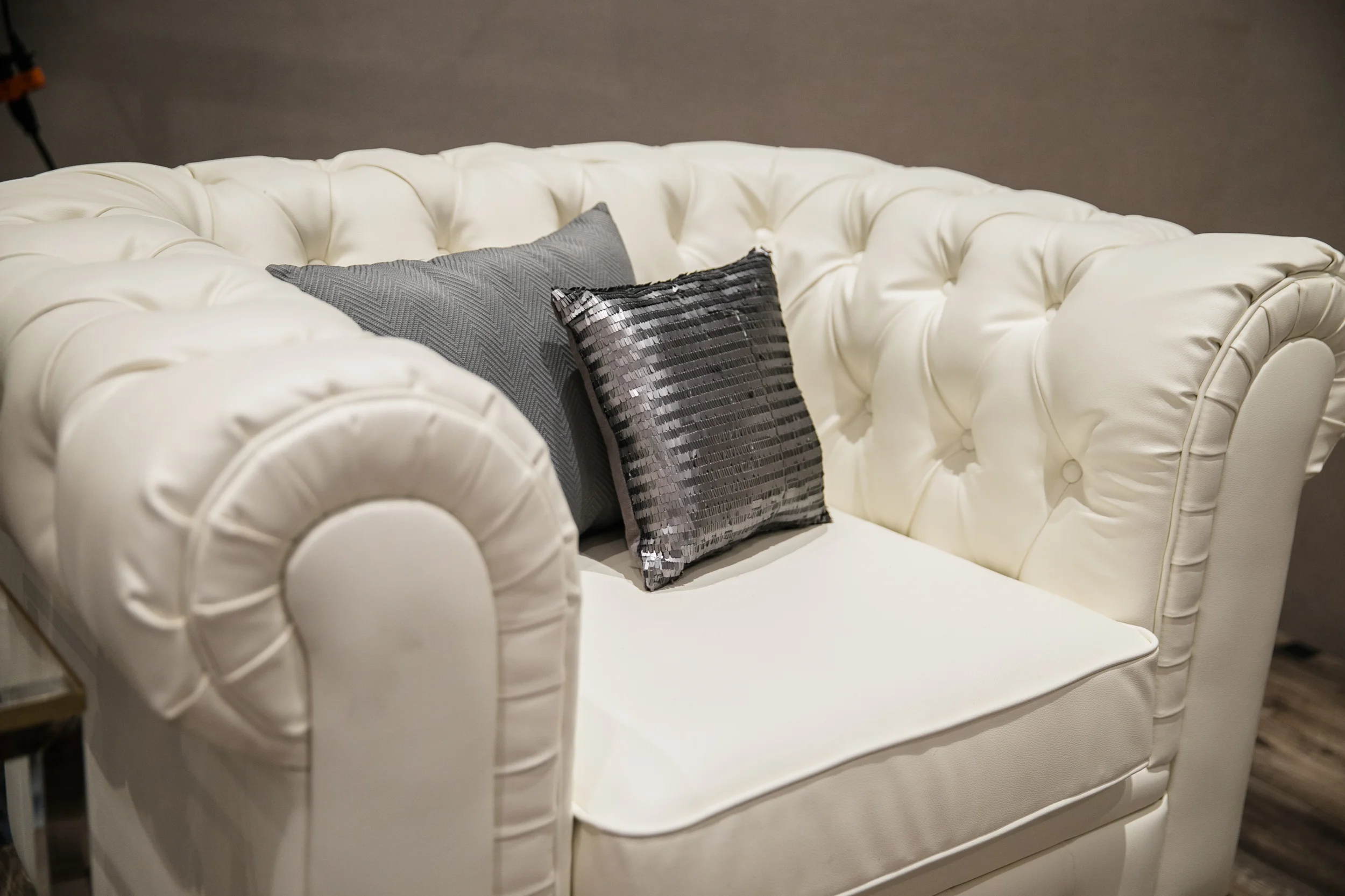 White tufted leather chairs with dark wooden feet.