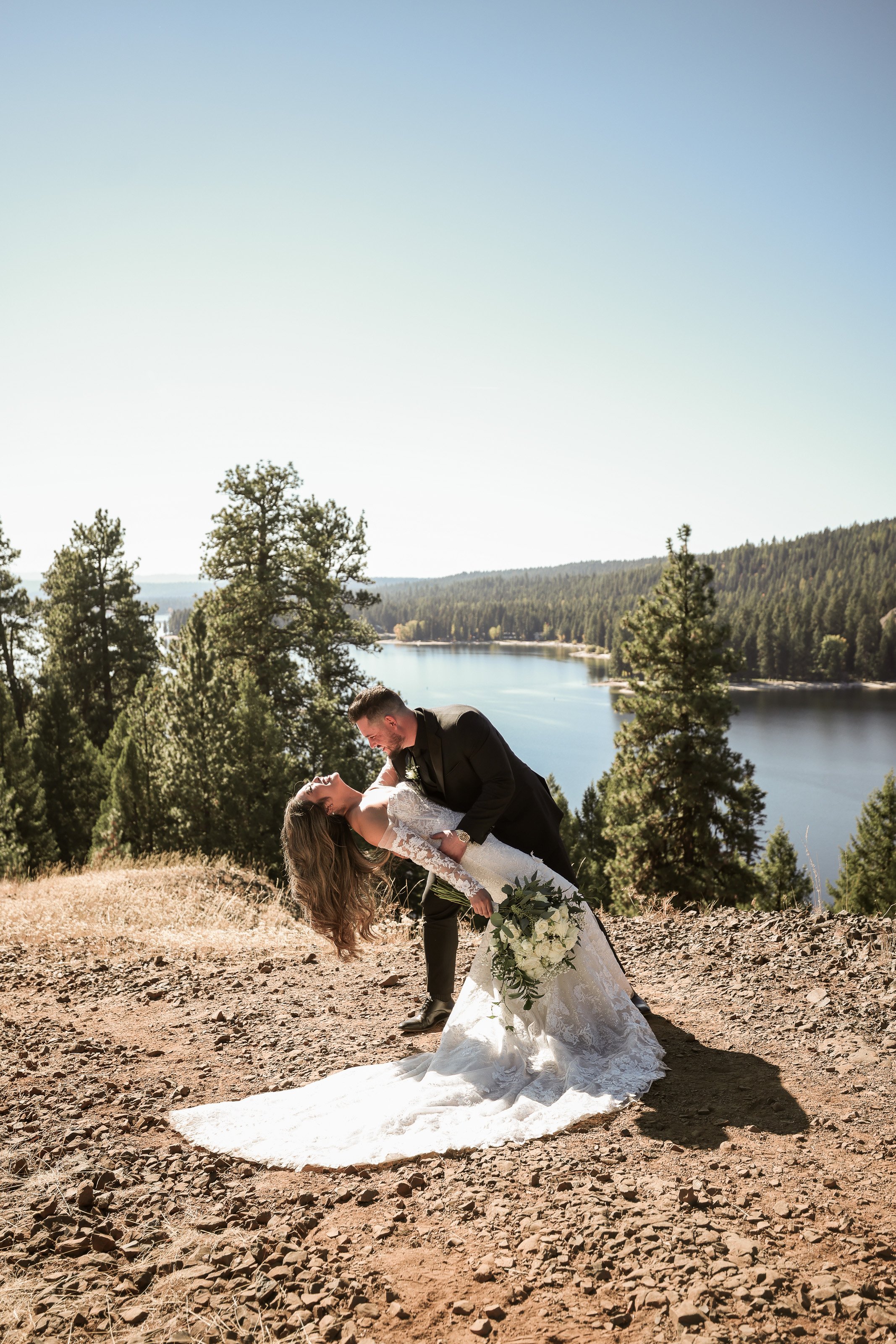 Groom Dips Bride with Lake behind