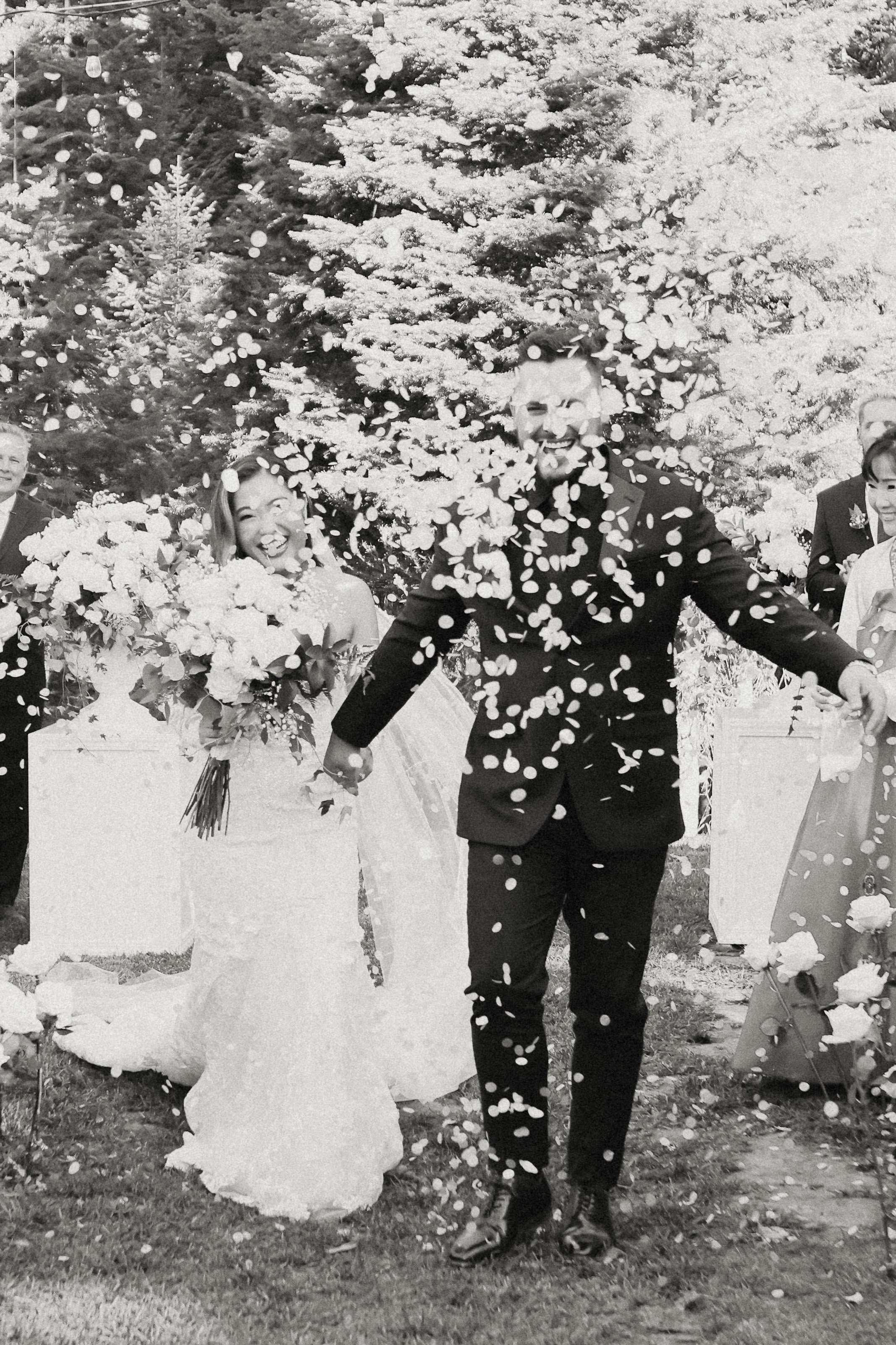 White petals thrown on wedding couple