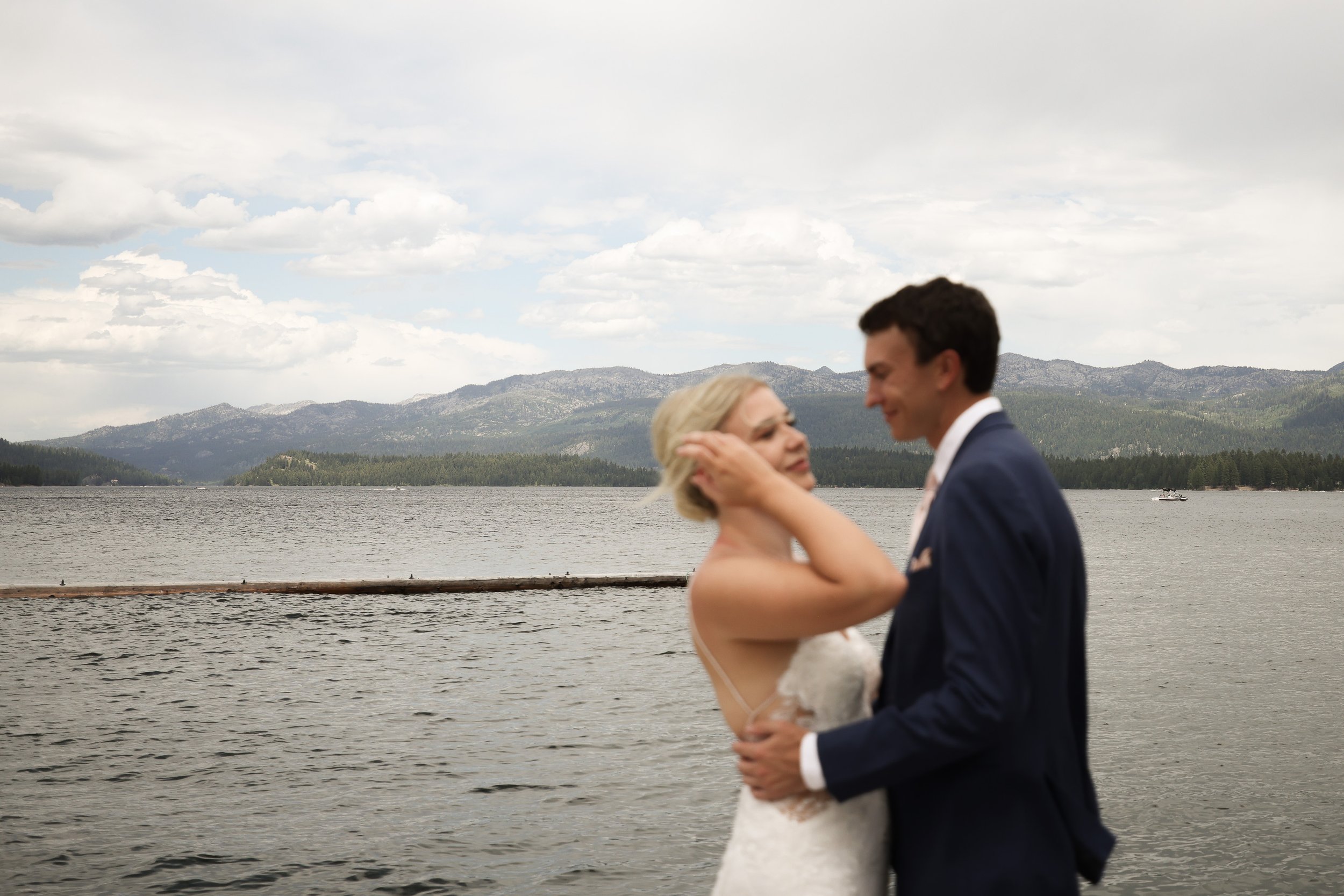 Bride and groom in wind at lake