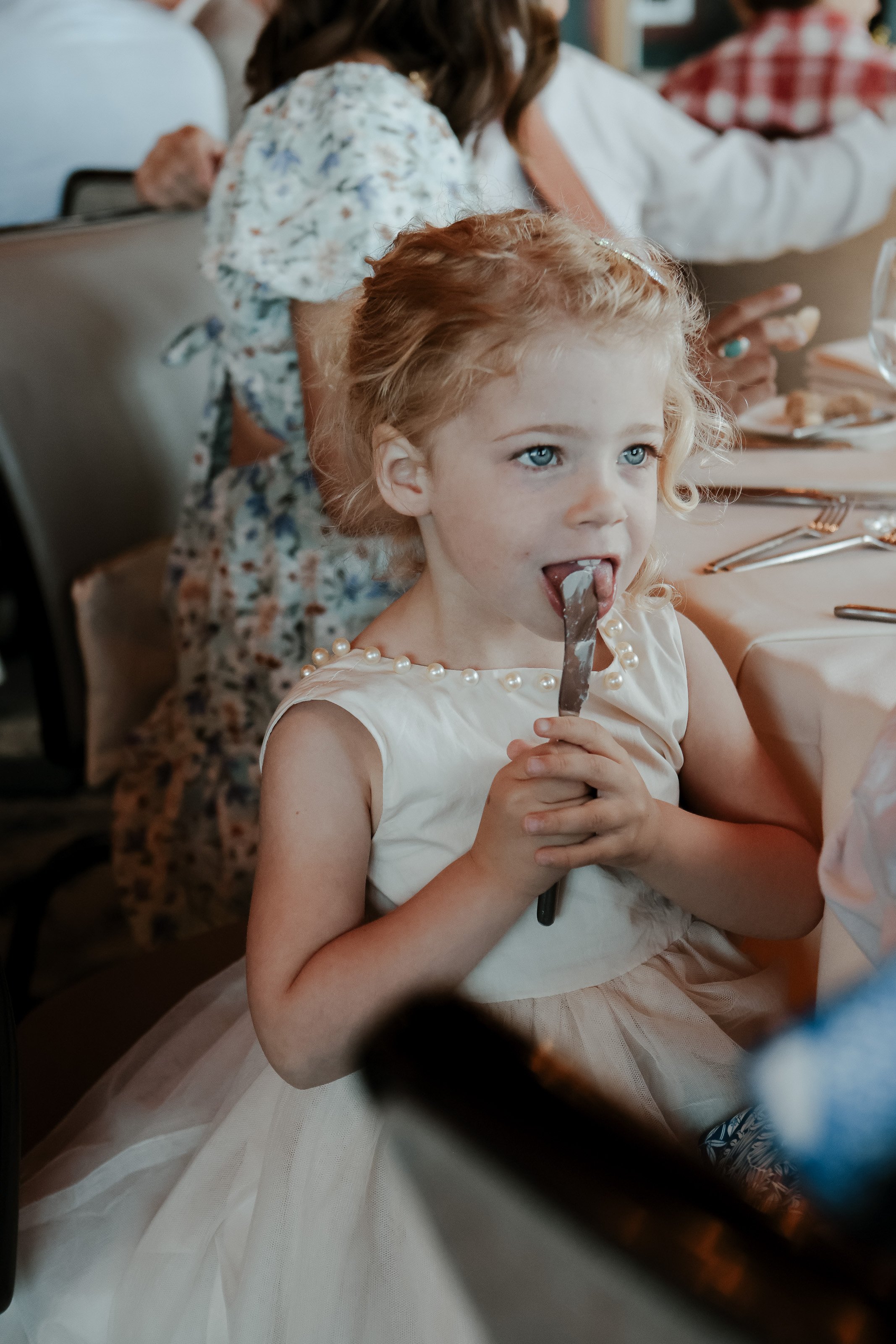 young wedding guest licks knife