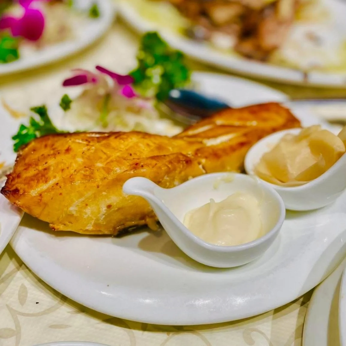 Look at that glaze. Our Honey Glazed Smoked Sea Bass comes out lacquered and gleaming &mdash; sweet, smoky, and rich, with creamy mayo and pickled ginger on the side to balance every bite. Cantonese seafood is what we do, alongside a made-to-order di