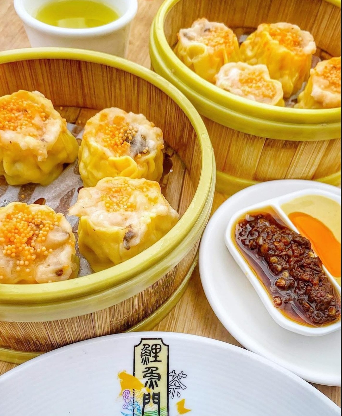 Open-topped pork and shrimp shiu mai, crowned with a generous spoonful of bright orange crab roe. Two steamers, a cup of tea, and a little dish of chili oil for dipping. Each one is made to order in our kitchen. The roe is what gives it that sweet, b