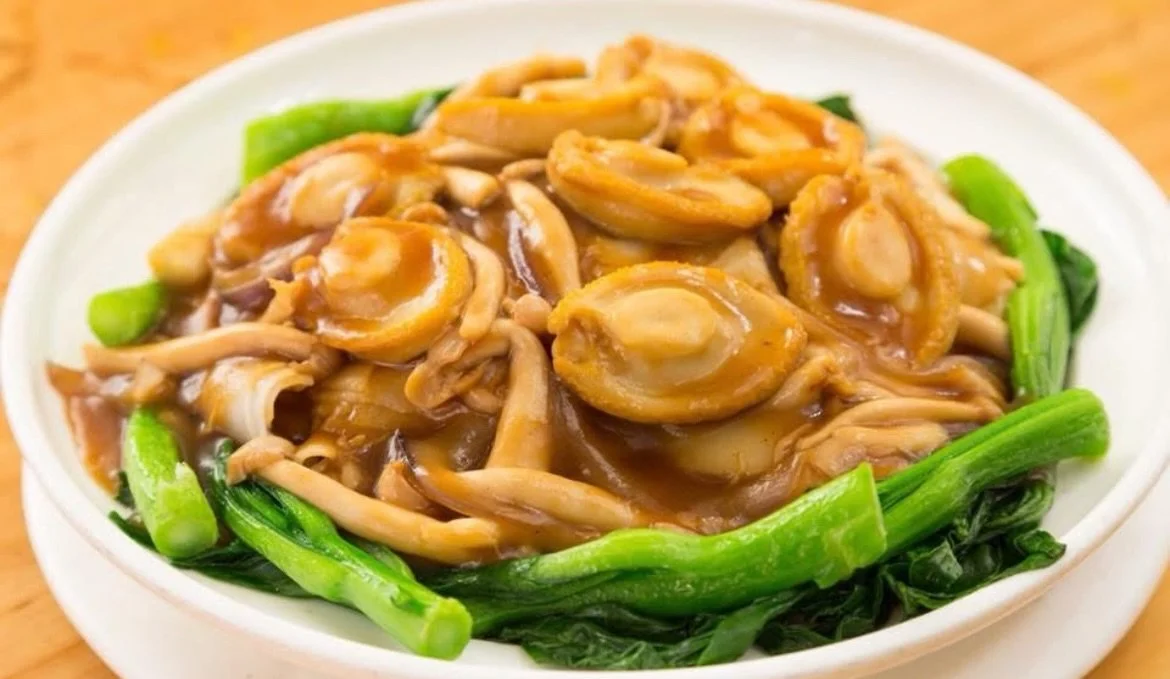 Wide rice noodles, glossy oyster-sauce gravy, whole baby abalone tucked among pan-seared mushrooms, ringed with bright Chinese broccoli. Cantonese banquet cooking, made to order. The kind of plate that quiets the table and sets the tone for the rest 