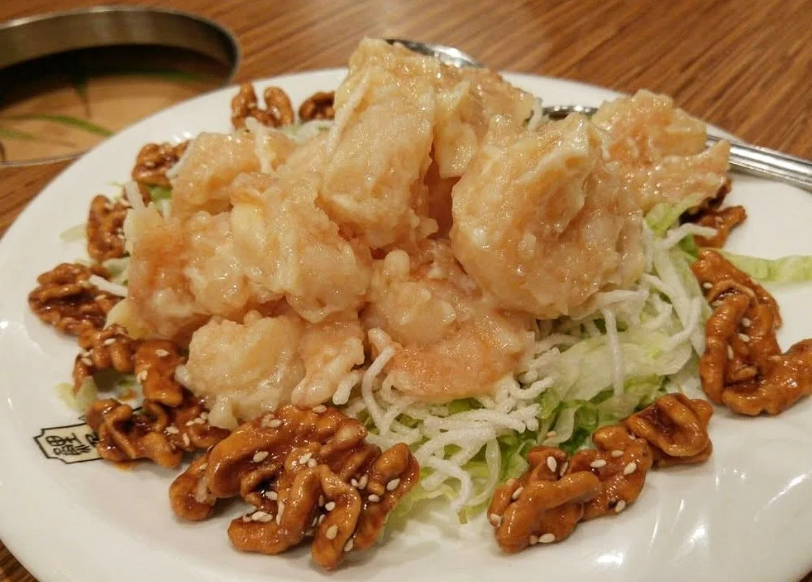 Honey Glazed Walnut Prawns &mdash; plump prawns in a creamy honey glaze, ringed by candied walnuts with a dusting of sesame, served over a bed of shredded greens. Sweet, crunchy, and a perennial favorite around the table. Made to order fresh from our
