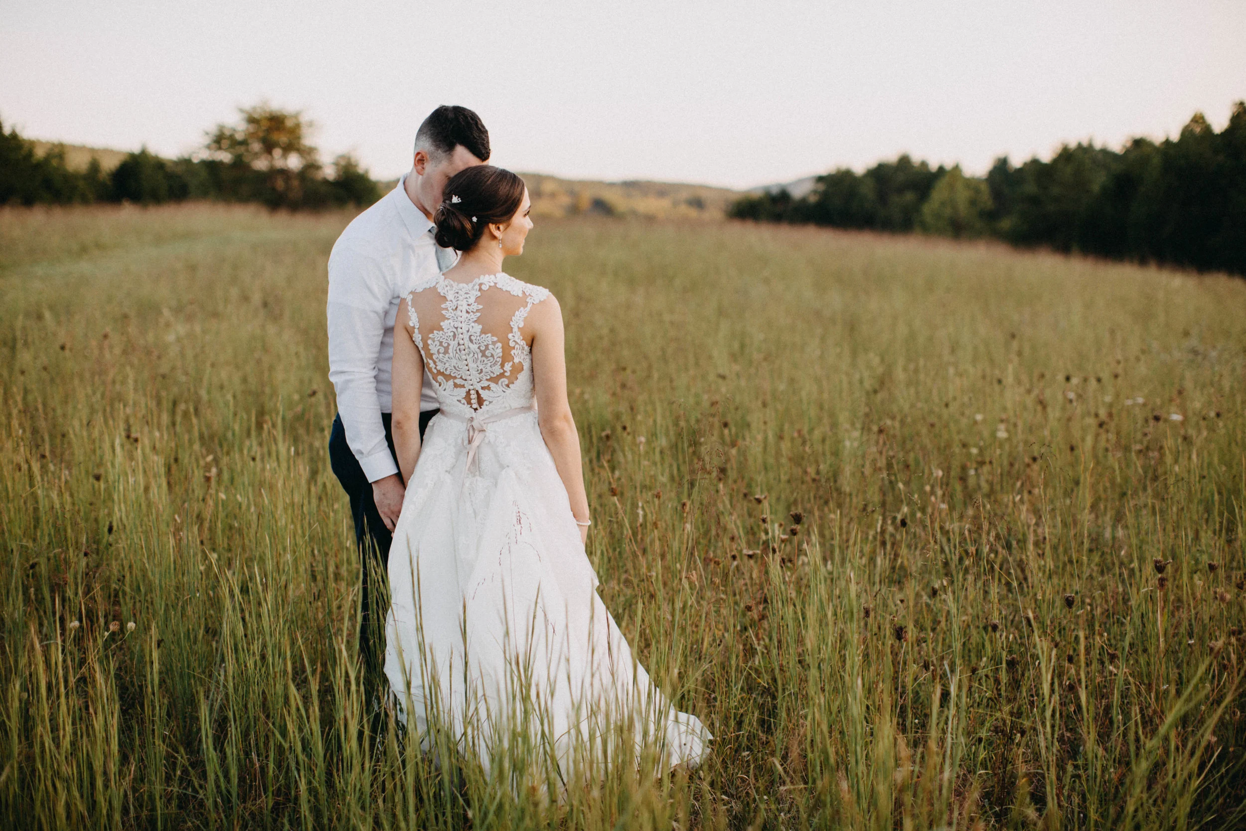 Portrait of couple standing together in field.