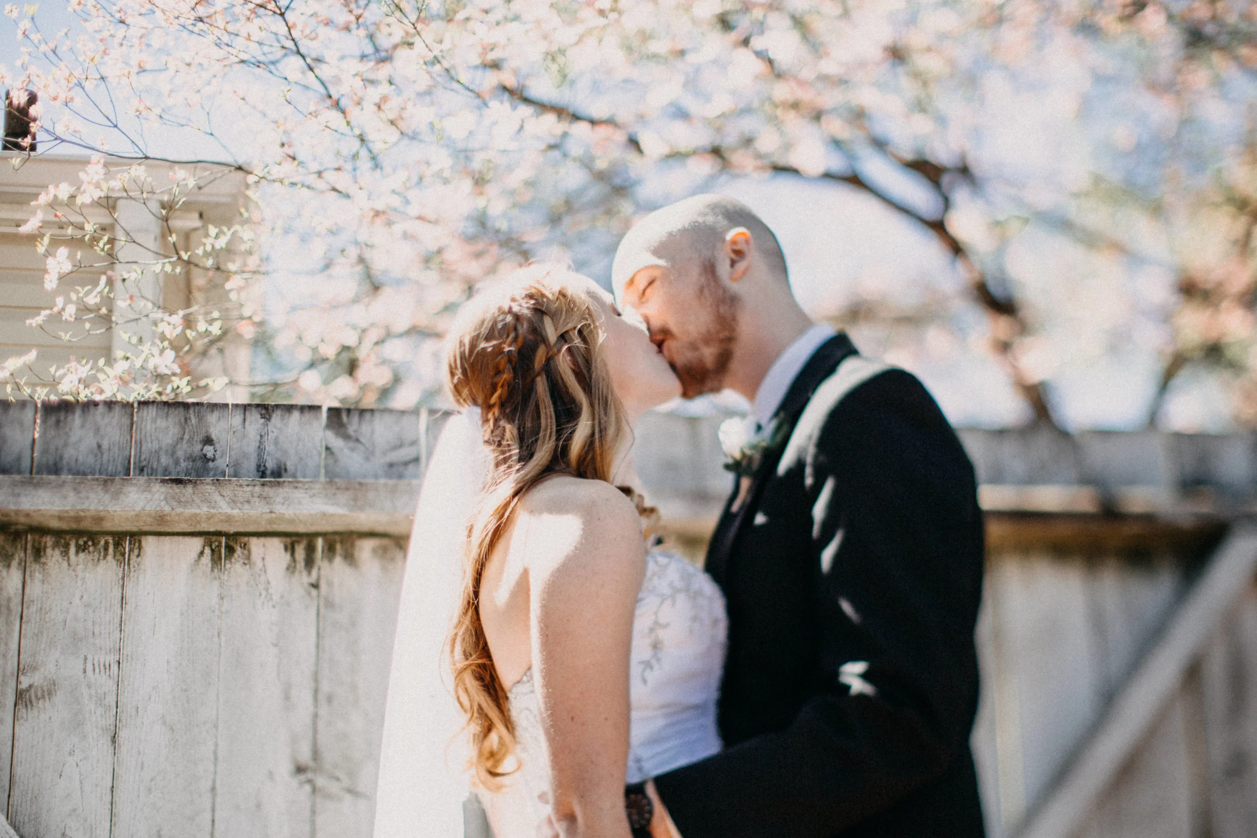 Portrait of couple kissing by fence.