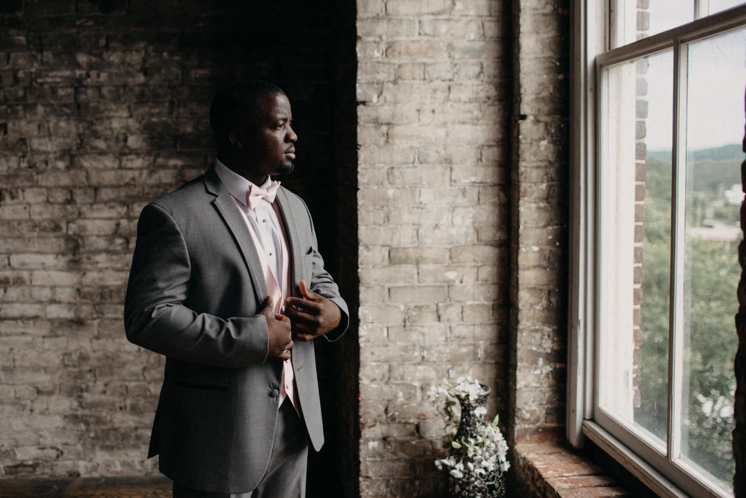 Portrait of groom standing beside window at Tresca on 8th, in VA.