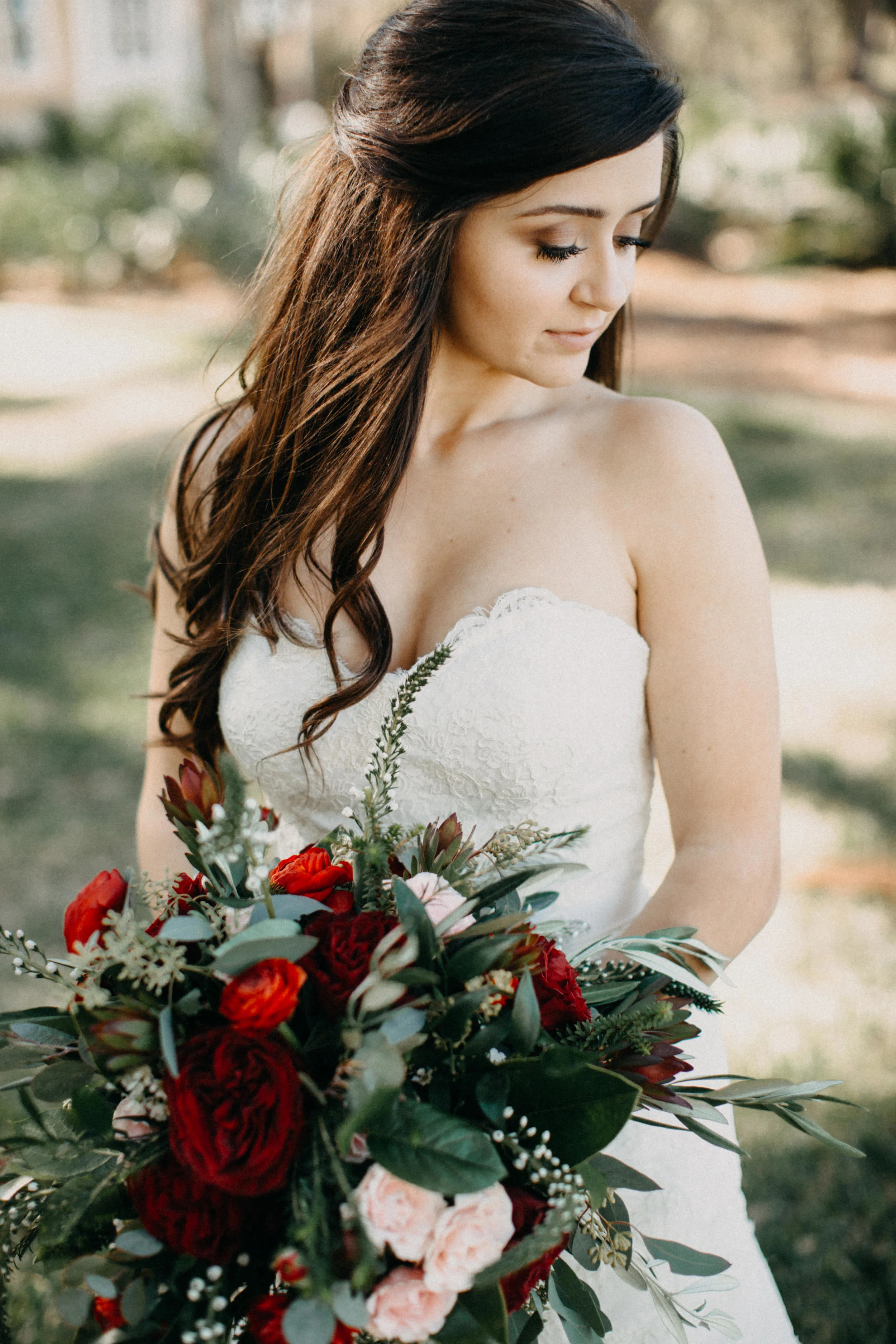 Portrait of bride standing with bouquet.