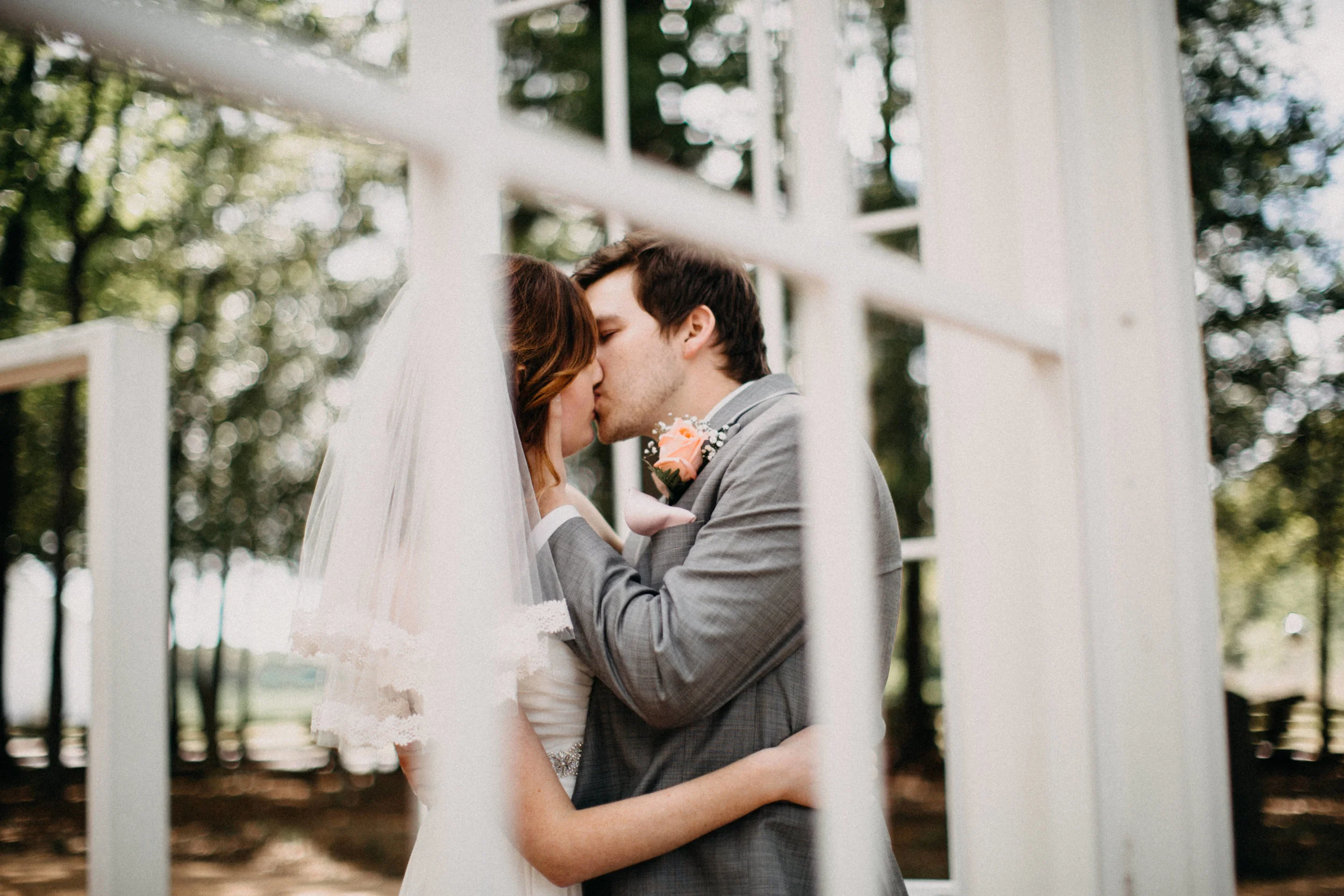 Portrait of couple kissing beside window.