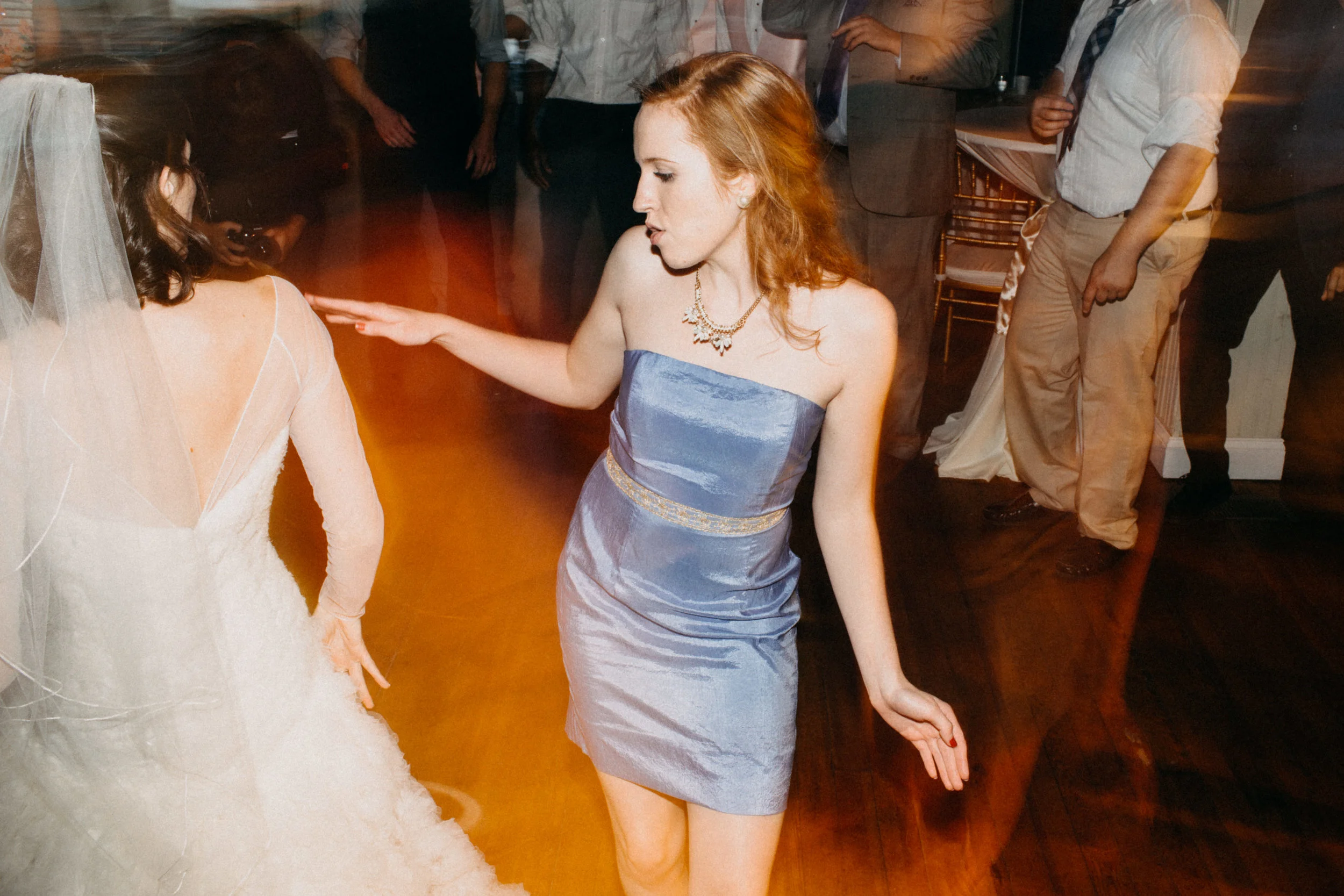 Photo of bride dancing with wedding guest at reception.