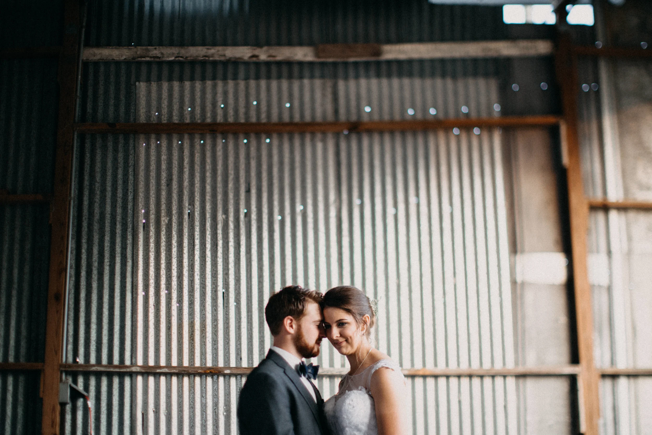 Portrait of couple standing in front of barn.