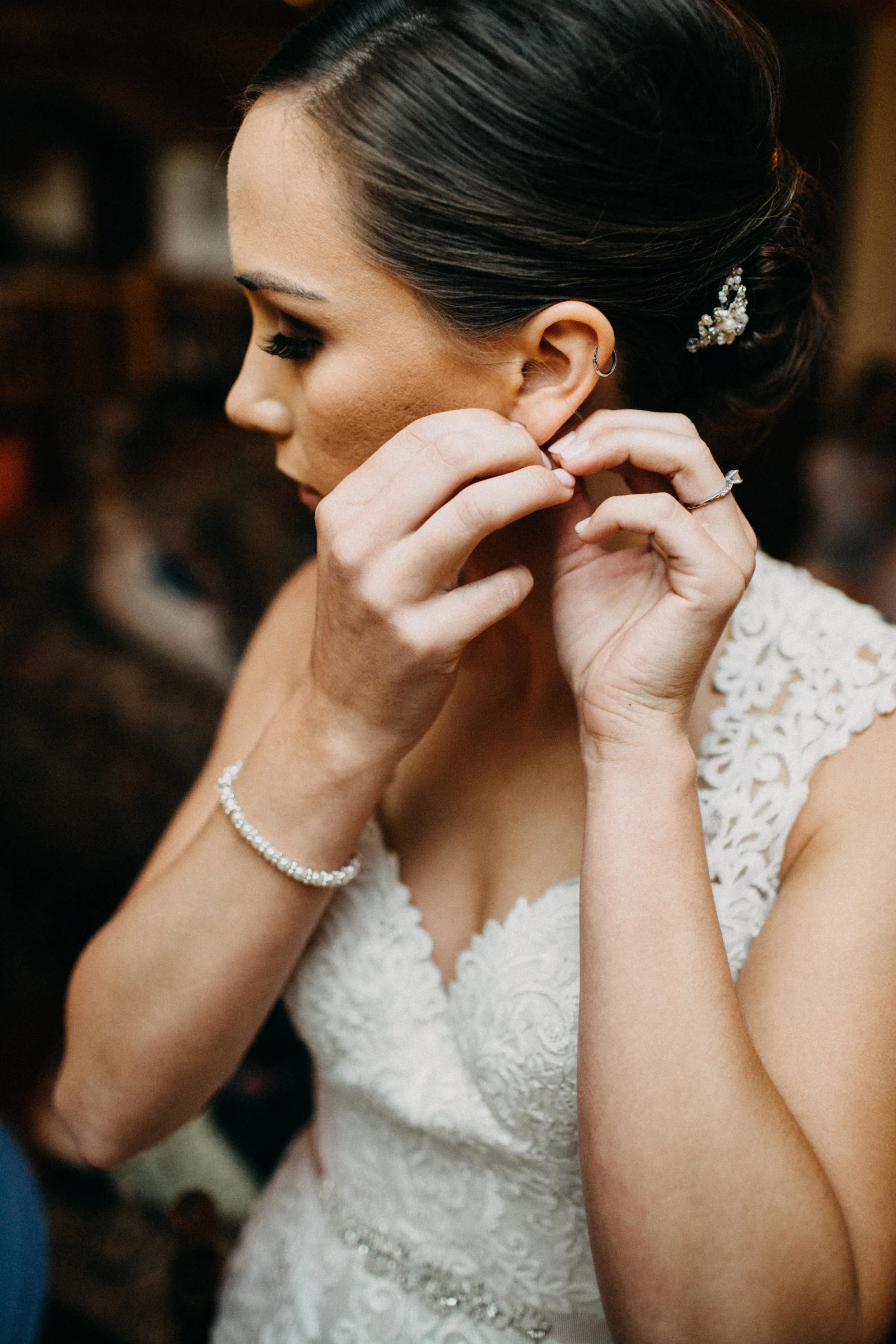 Portrait of bride putting on earrings.