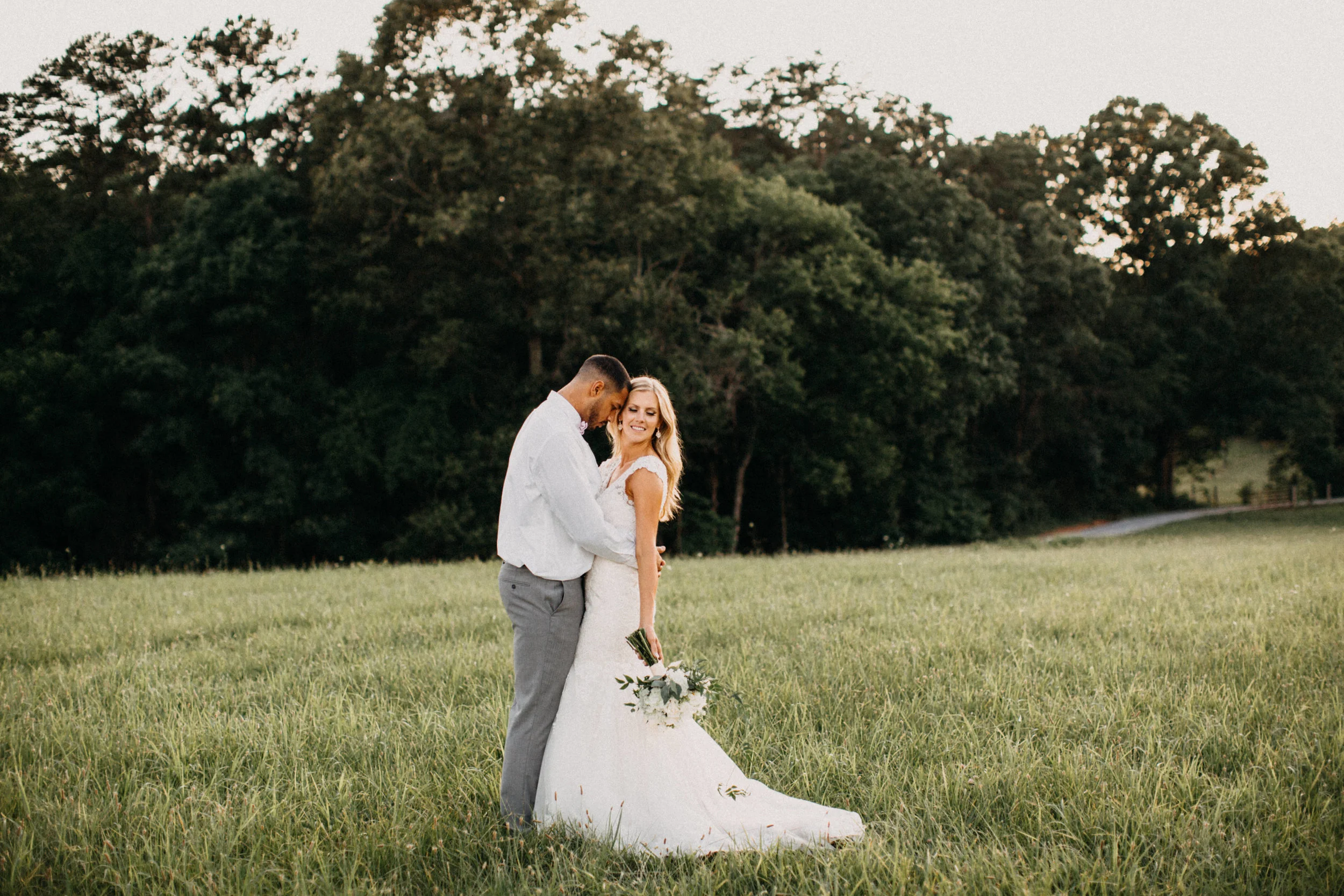 Portrait of couple embracing in a field.