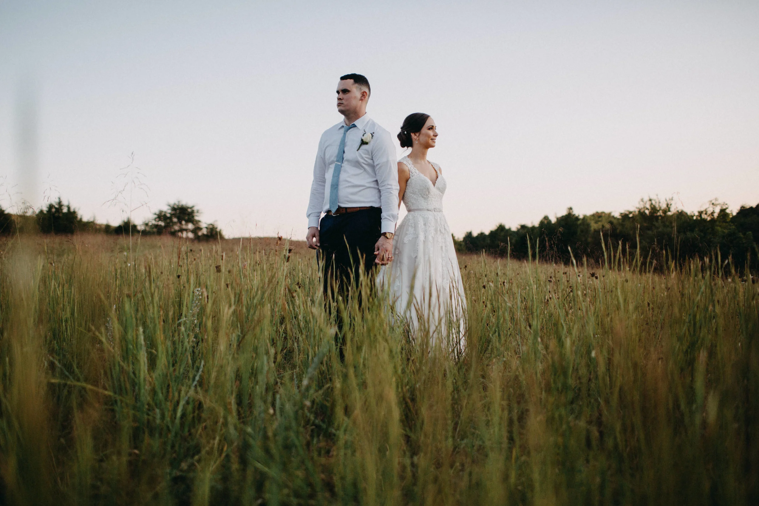 Portrait of couple standing together in field.
