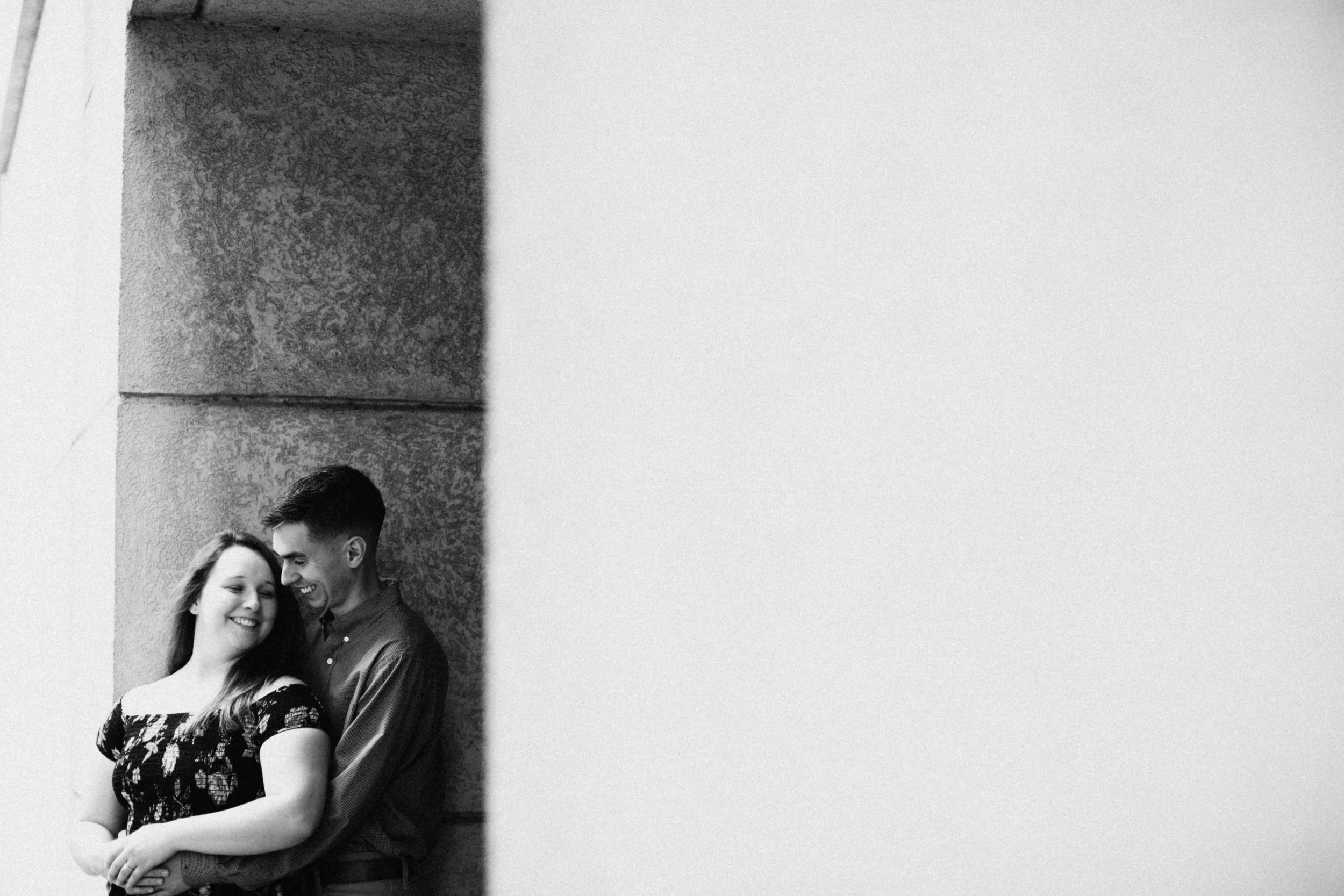 Couple leaning against wall.